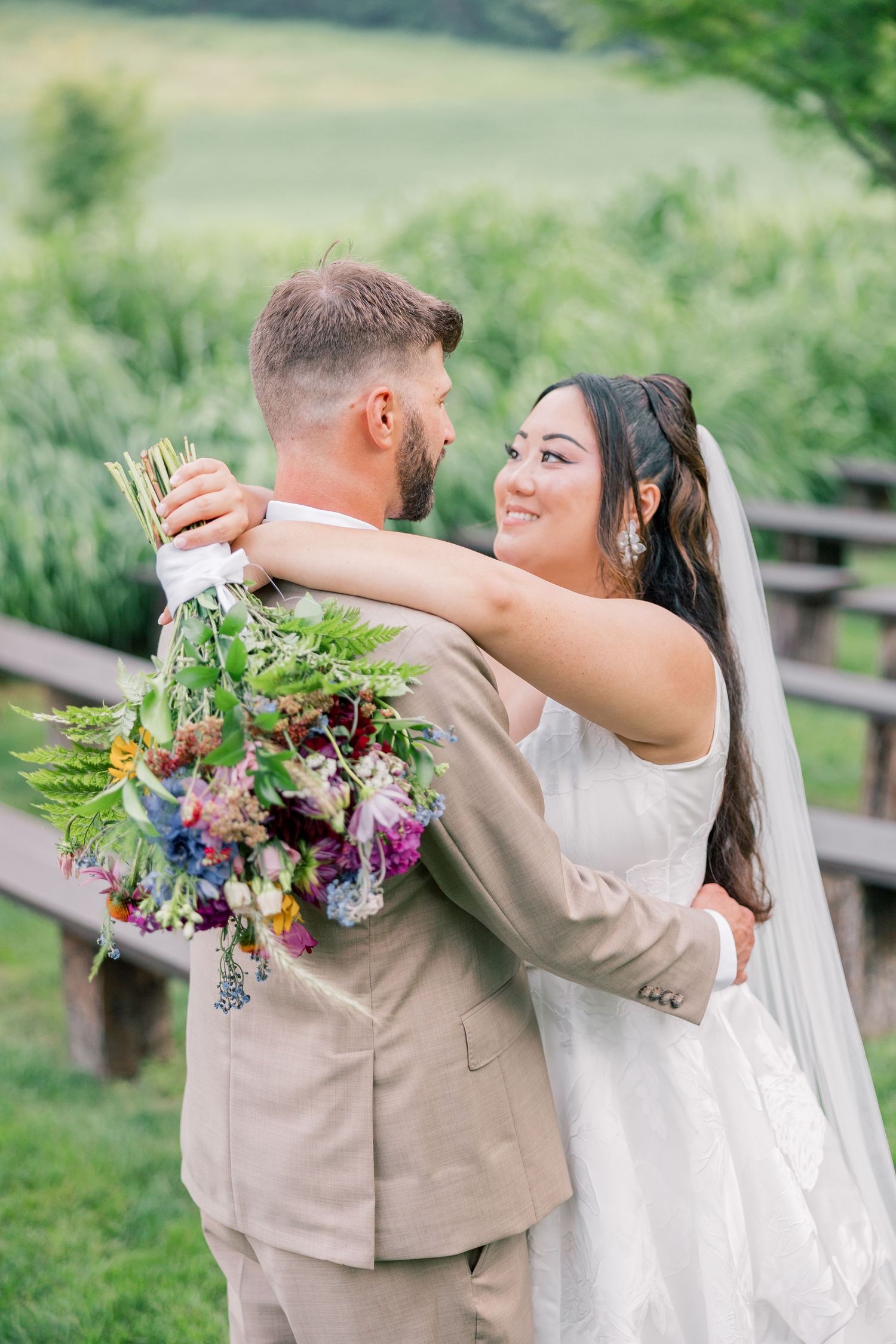 A romantic outdoor wedding moment with flowing florals and natural greenery in the background.
