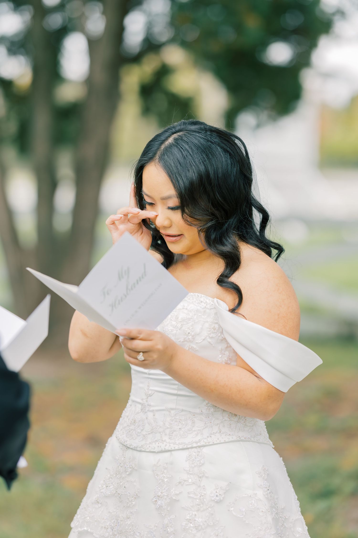 A series of emotional moments reading a letter while wearing a white lace wedding dress in an outdoor setting.