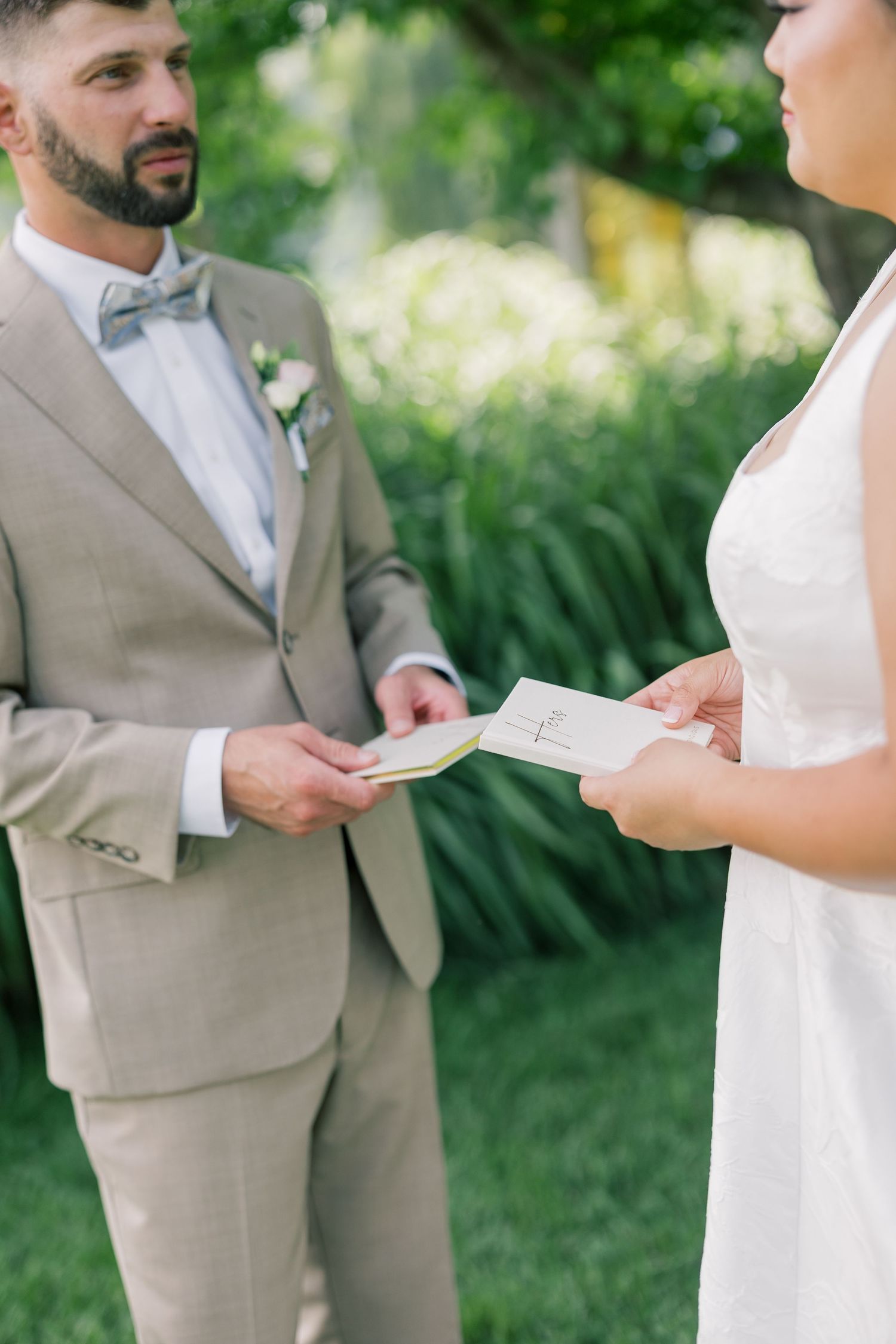 Wedding ceremony moment as couple exchanges vows in an outdoor garden setting.