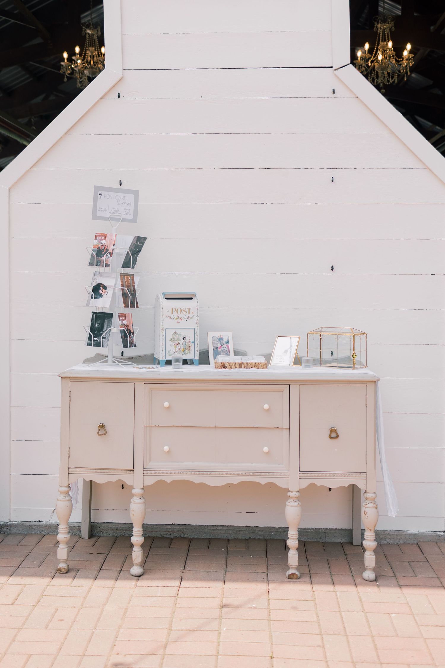 Vintage-style pink dresser with decorative displays against a white shiplap wall.