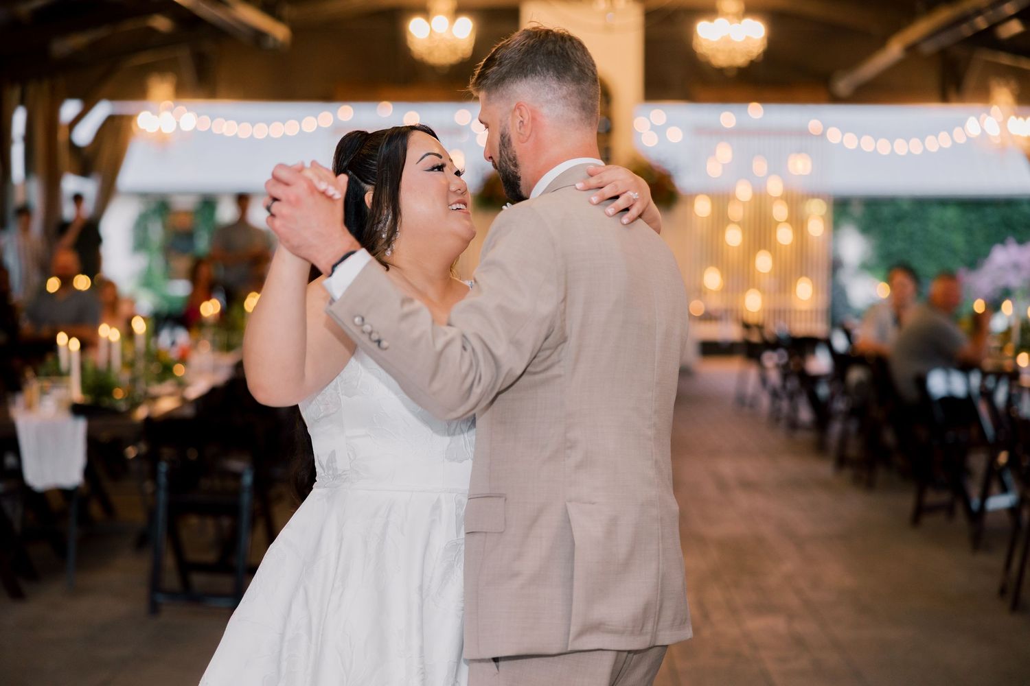 A romantic wedding reception scene with string lights and elegant decor creating a warm ambiance.