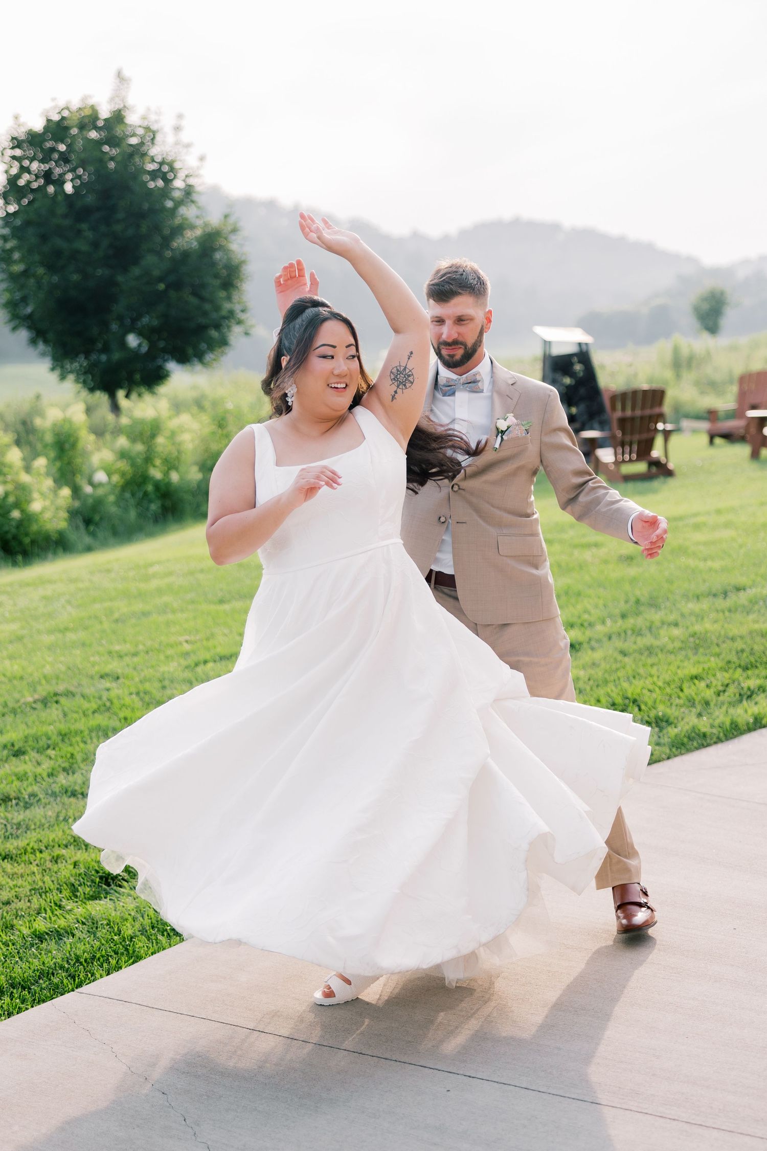 A joyful couple dances together on their wedding day, with the bride's dress twirling.