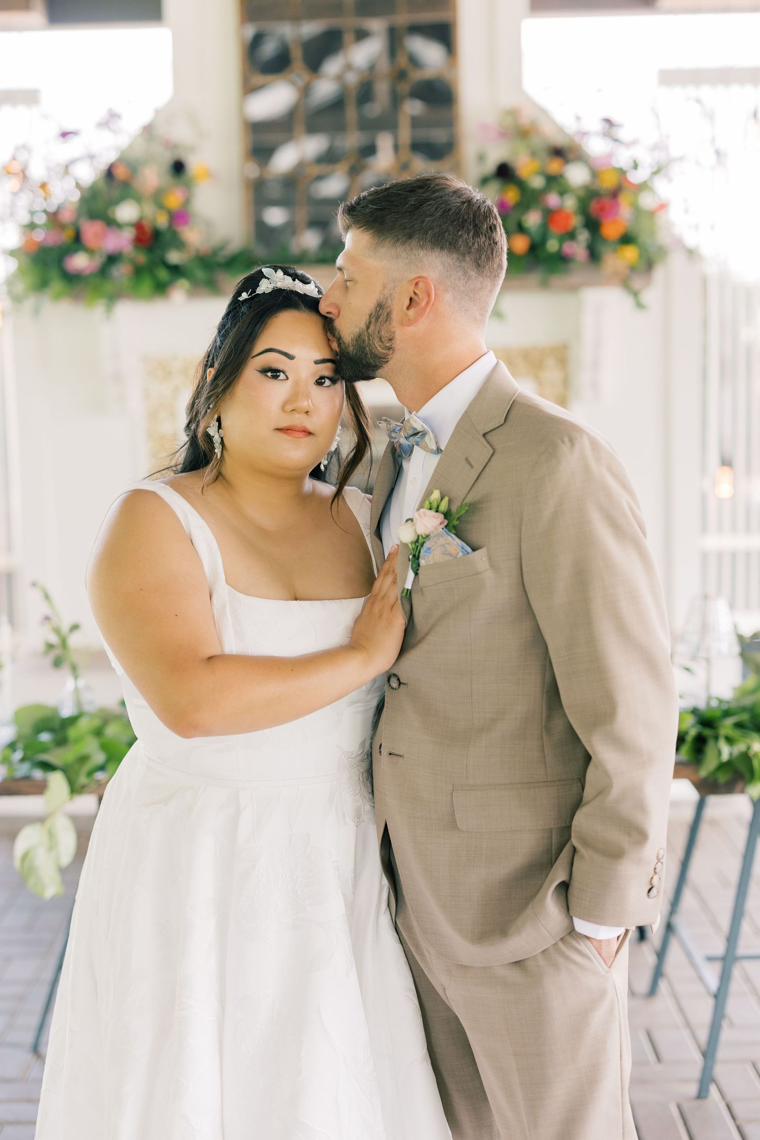 Romantic wedding couple poses in three elegant shots against a floral decorated venue backdrop.