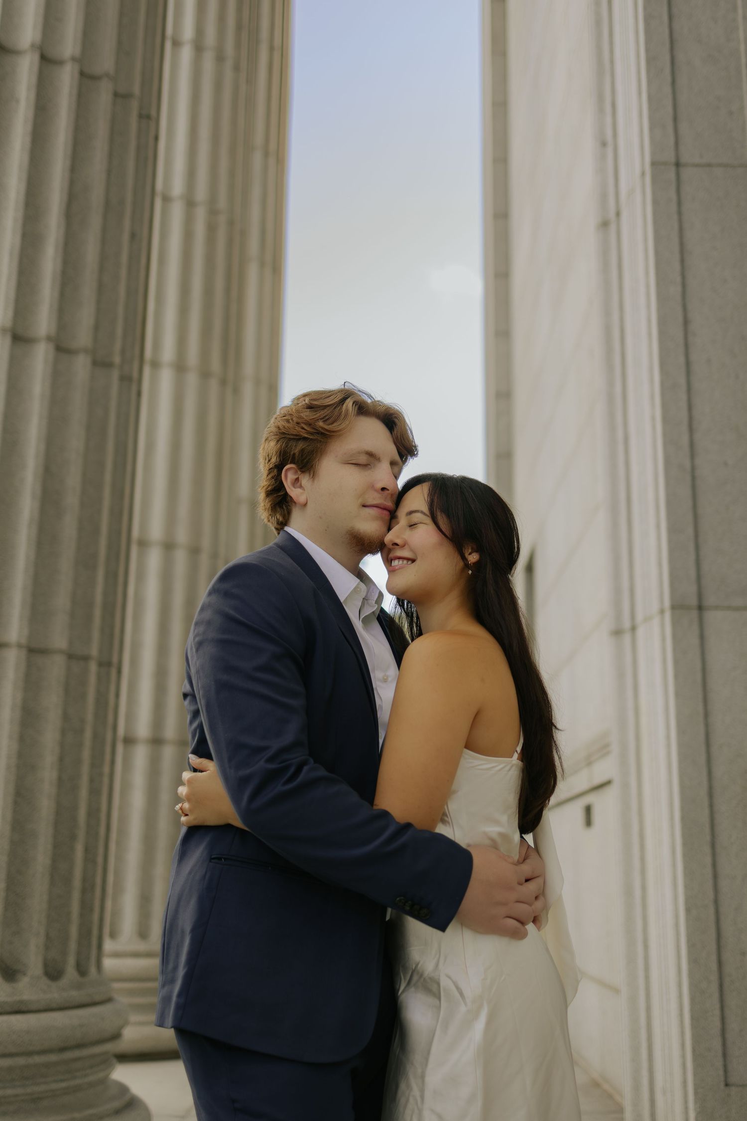 Romantic wedding couple shares intimate kisses in front of classical stone columns in a series of photos.