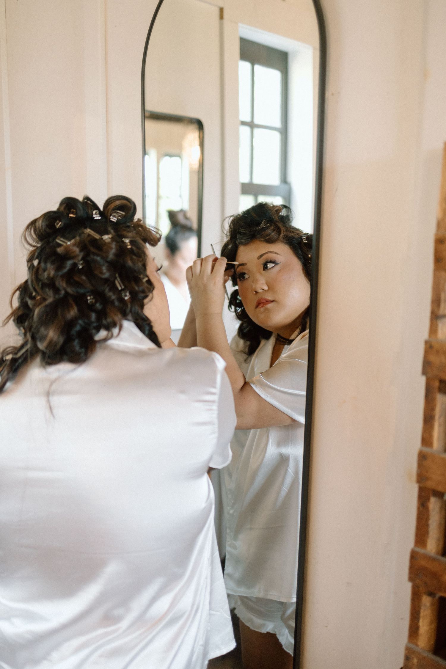 Multiple reflections in a series of mirrors showing someone adjusting their hair.