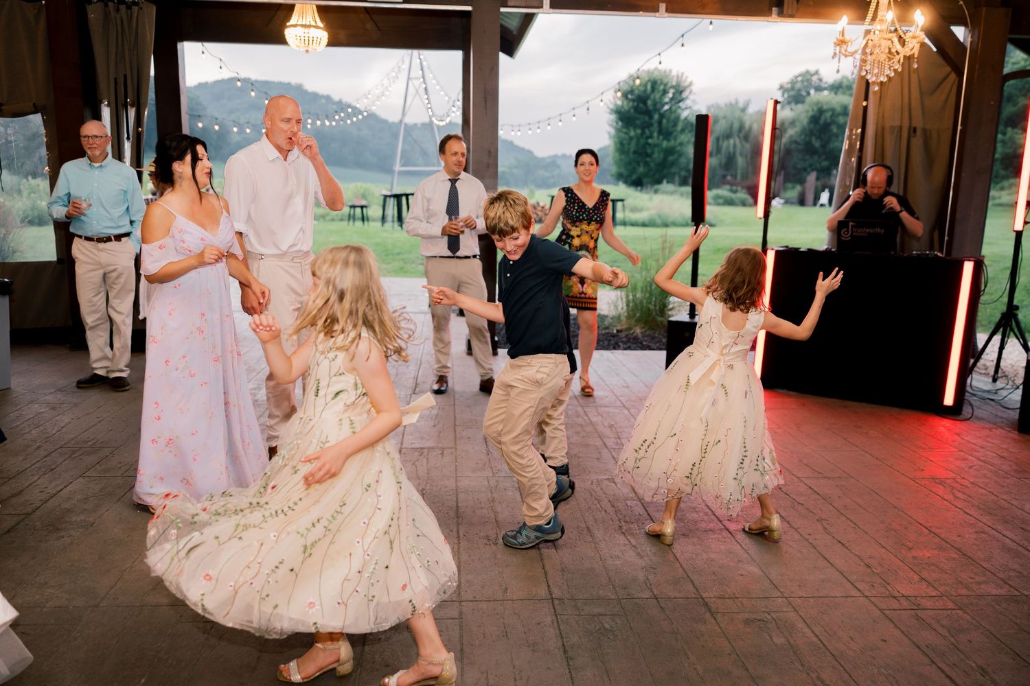 Wedding reception dance floor filled with guests celebrating under warm lighting.