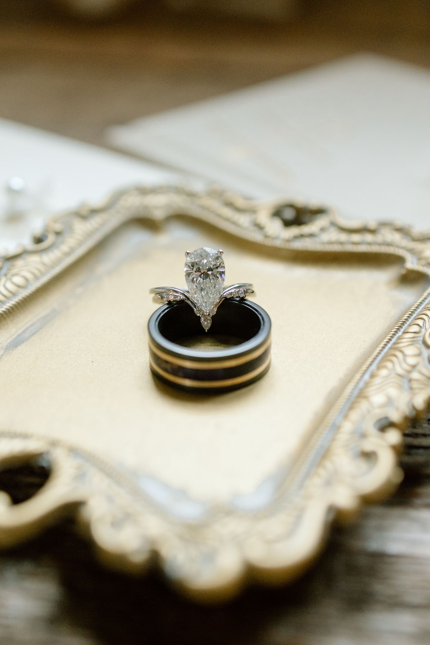 Close-up shots of elegant diamond engagement rings displayed on a decorative surface.