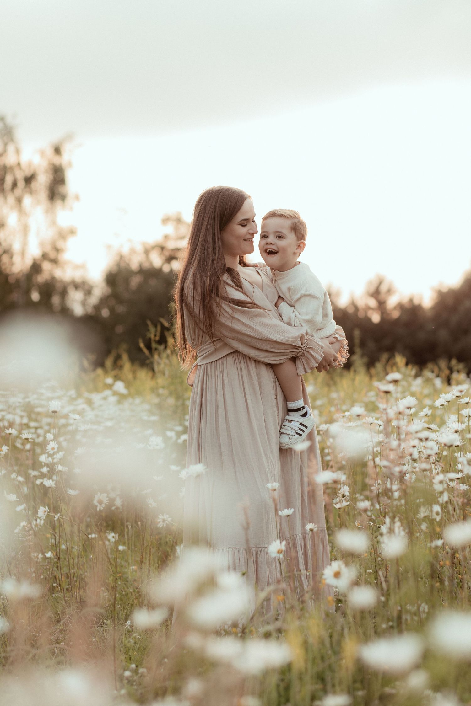 Mama met haar zoon bij een minishoot op een wit bloemenveld in Eindhoven.