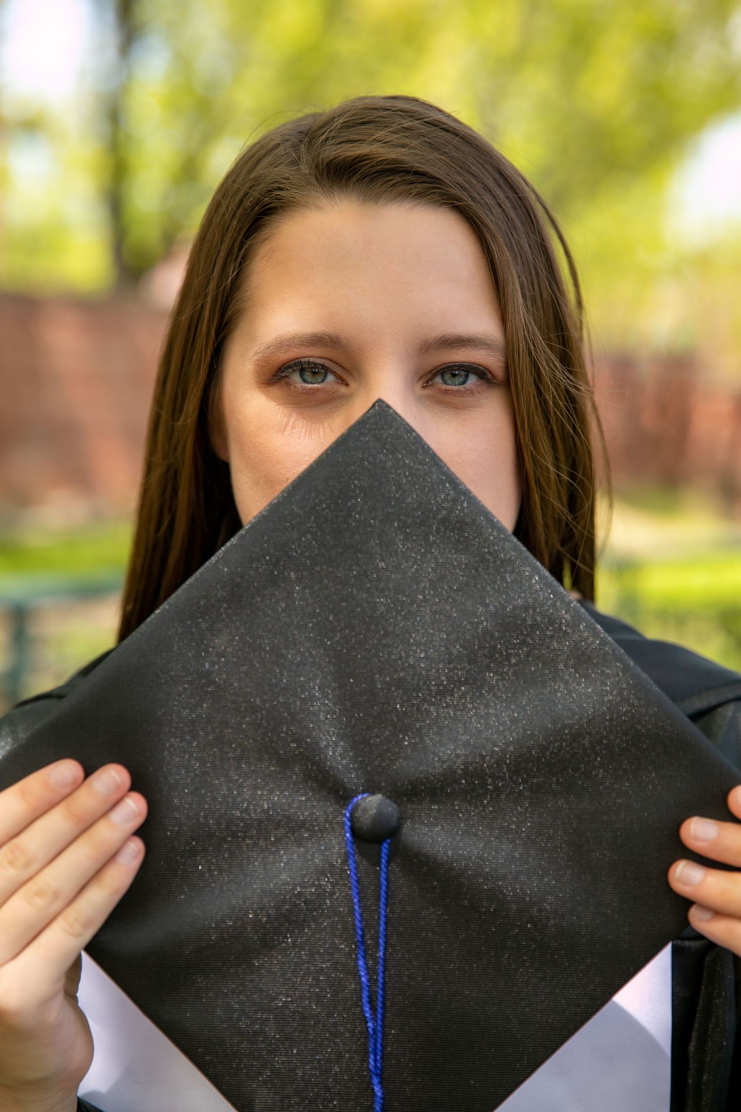 A graduation cap is progressively folded in a sequence of photos showing the steps to create a decorative design.