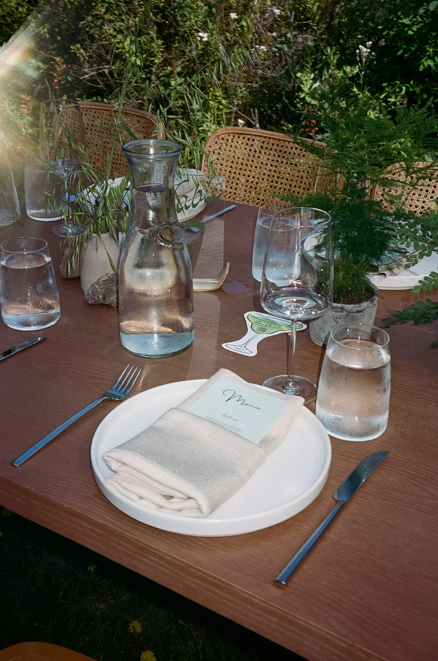 Rustic wedding table setting with greenery centerpieces and water glasses. Film Photograph in the PNW Pacific Northwest.