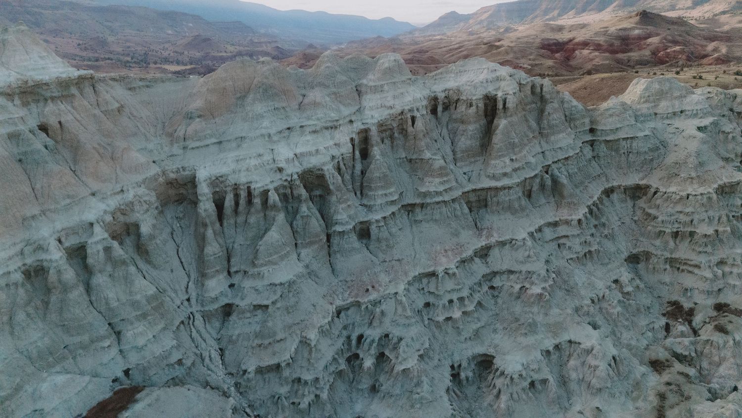 Panoramic view of rugged mountain cliffs and canyons in a desert landscape.