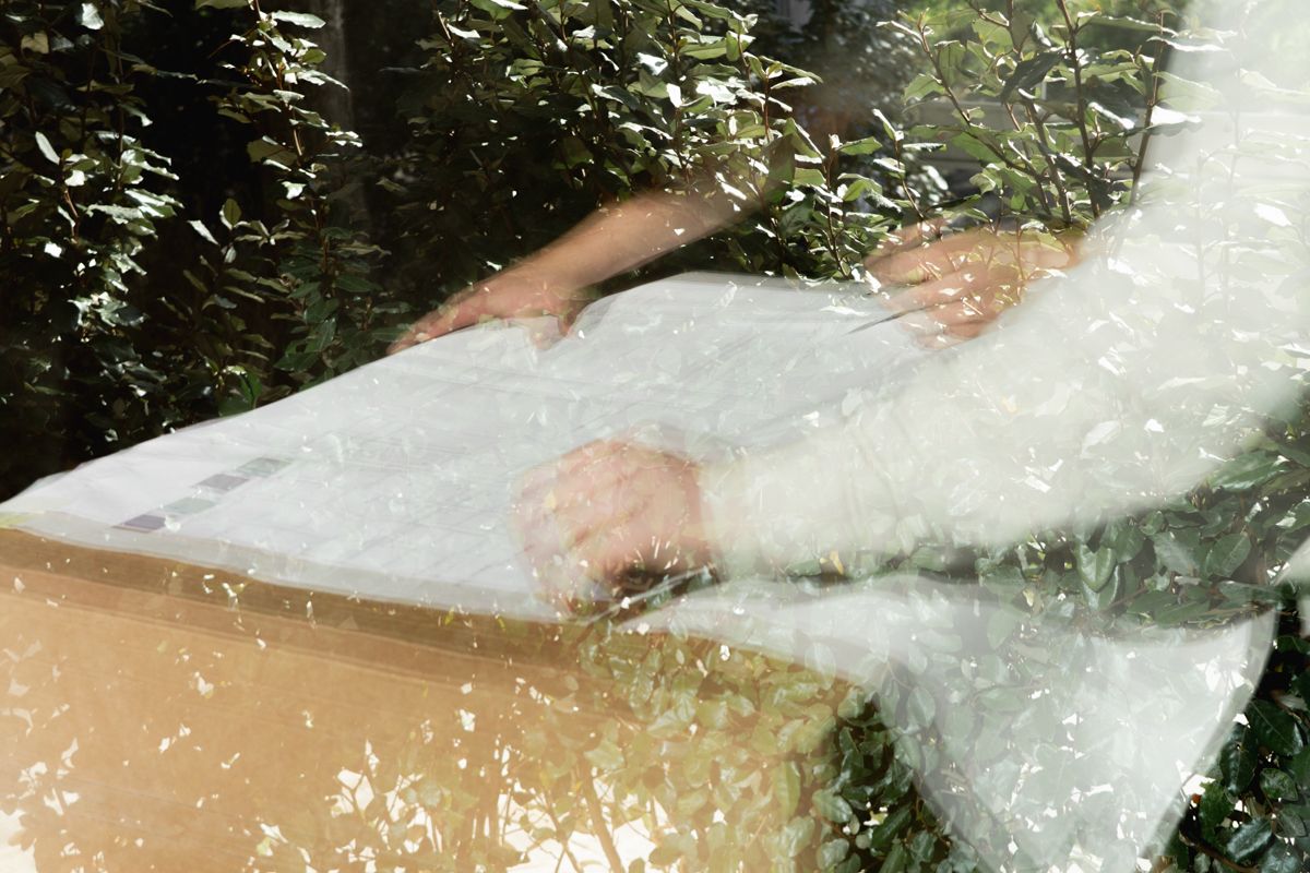 Man in crème trui met tekst bekijkt materialen, branding fotoshoot Format Massimo door Eva Berendse