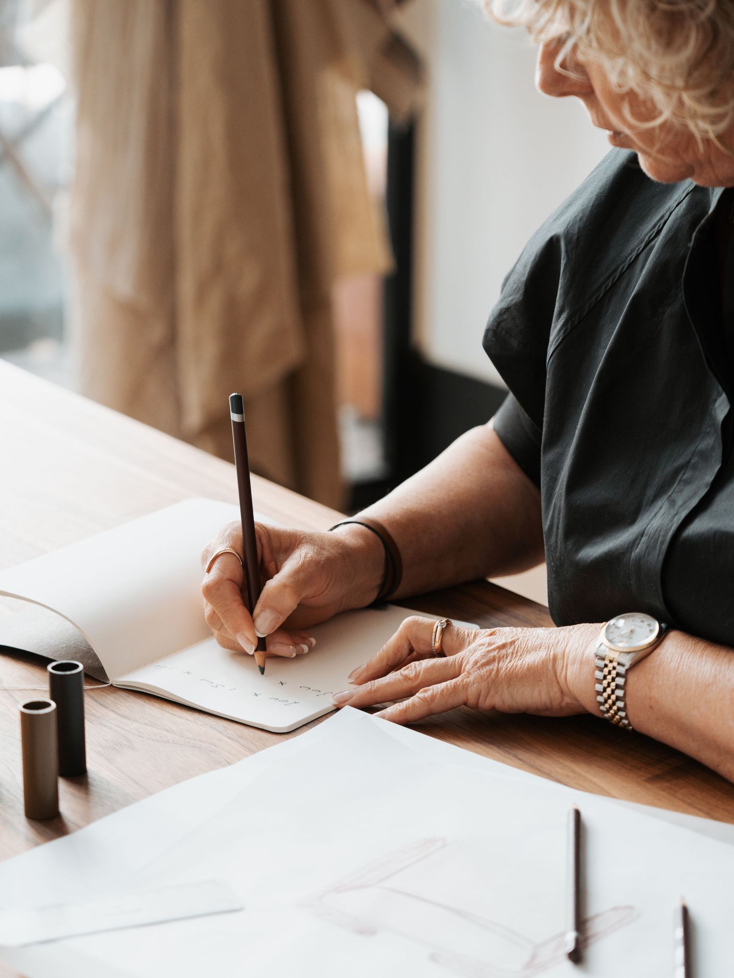 Persoon schrijft en tekent meubelontwerpen op papier, Format Furniture bedrijfsfotografie Eva Berendse