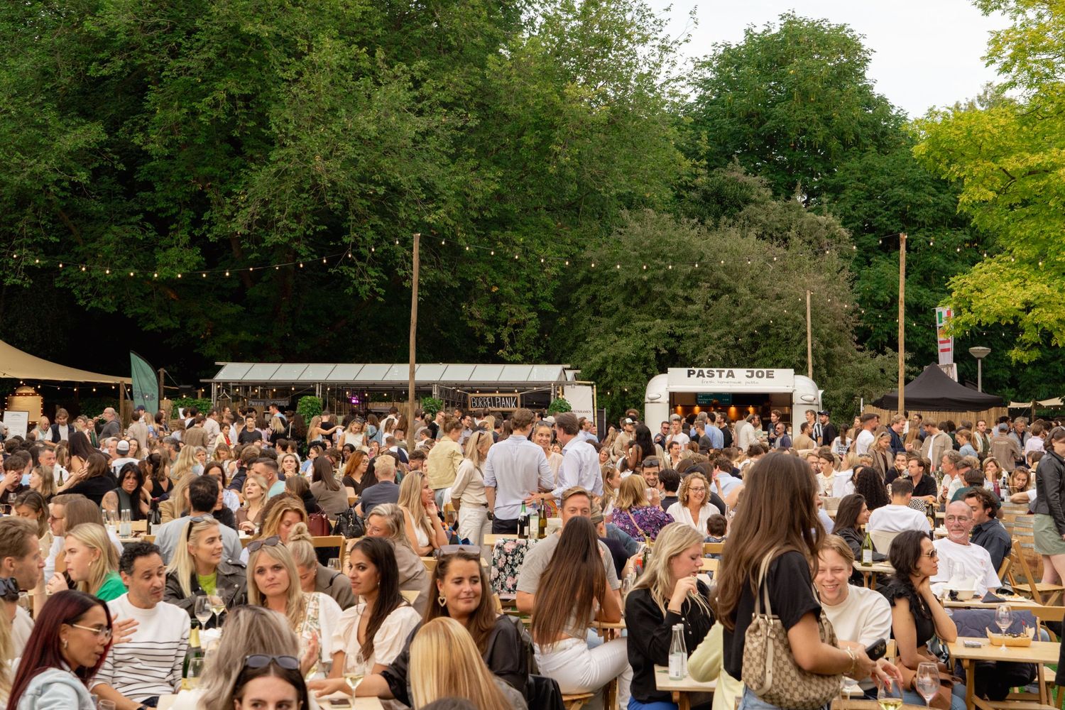 Bezoekers genieten van wijn op outdoor festival, fotografie door Eva Berendse