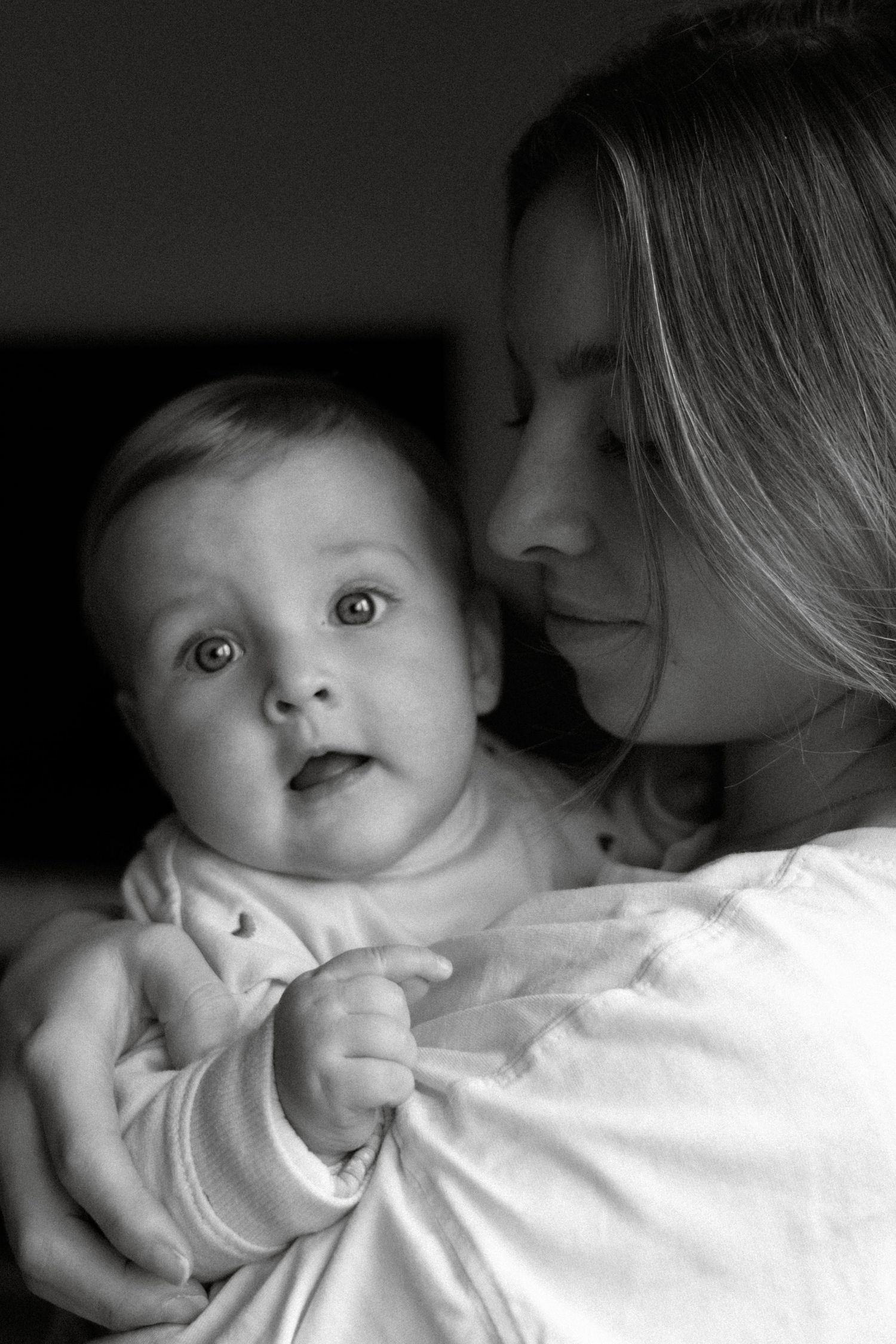 Baby in armen van moeder, zachte en warme newborn fotografie door Eva Berendse
