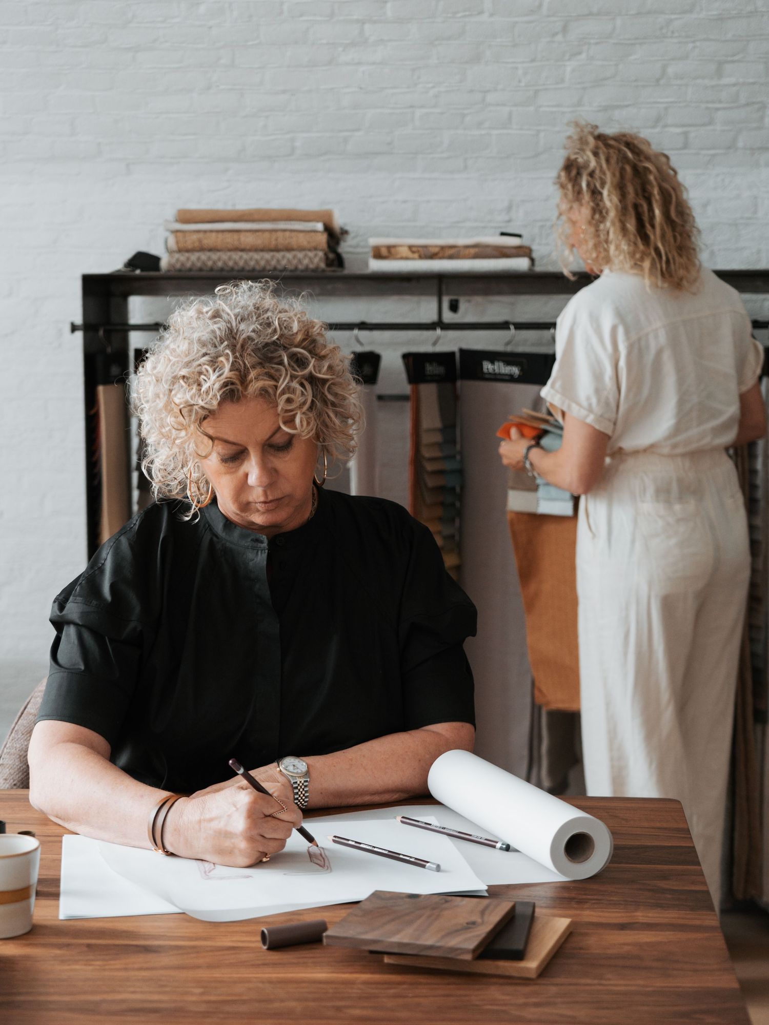 Ontwerper bekijkt meubelplannen aan werktafel, Format Furniture bedrijfsfotografie door Eva Berendse