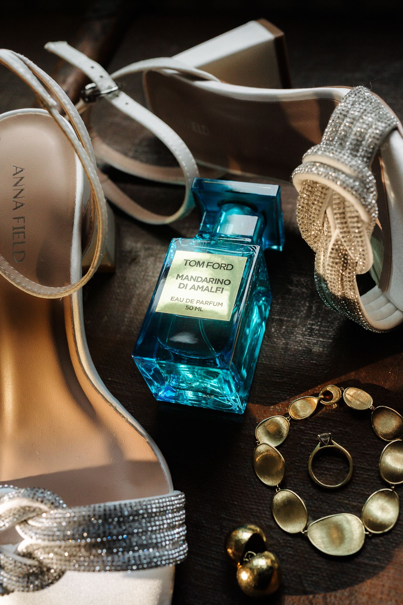 Tom Ford Mandarino di Amalfi perfume surrounded by silver bridal shoes and jewelry.