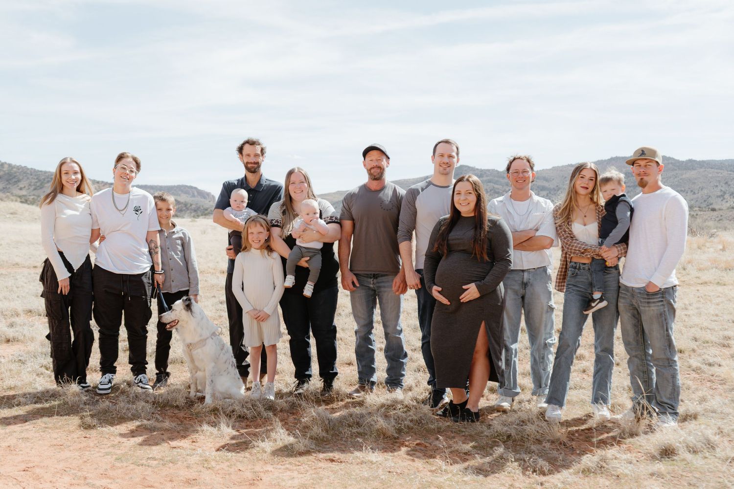 Large family group posing together outdoors in a desert landscape for a professional family portrait photo.