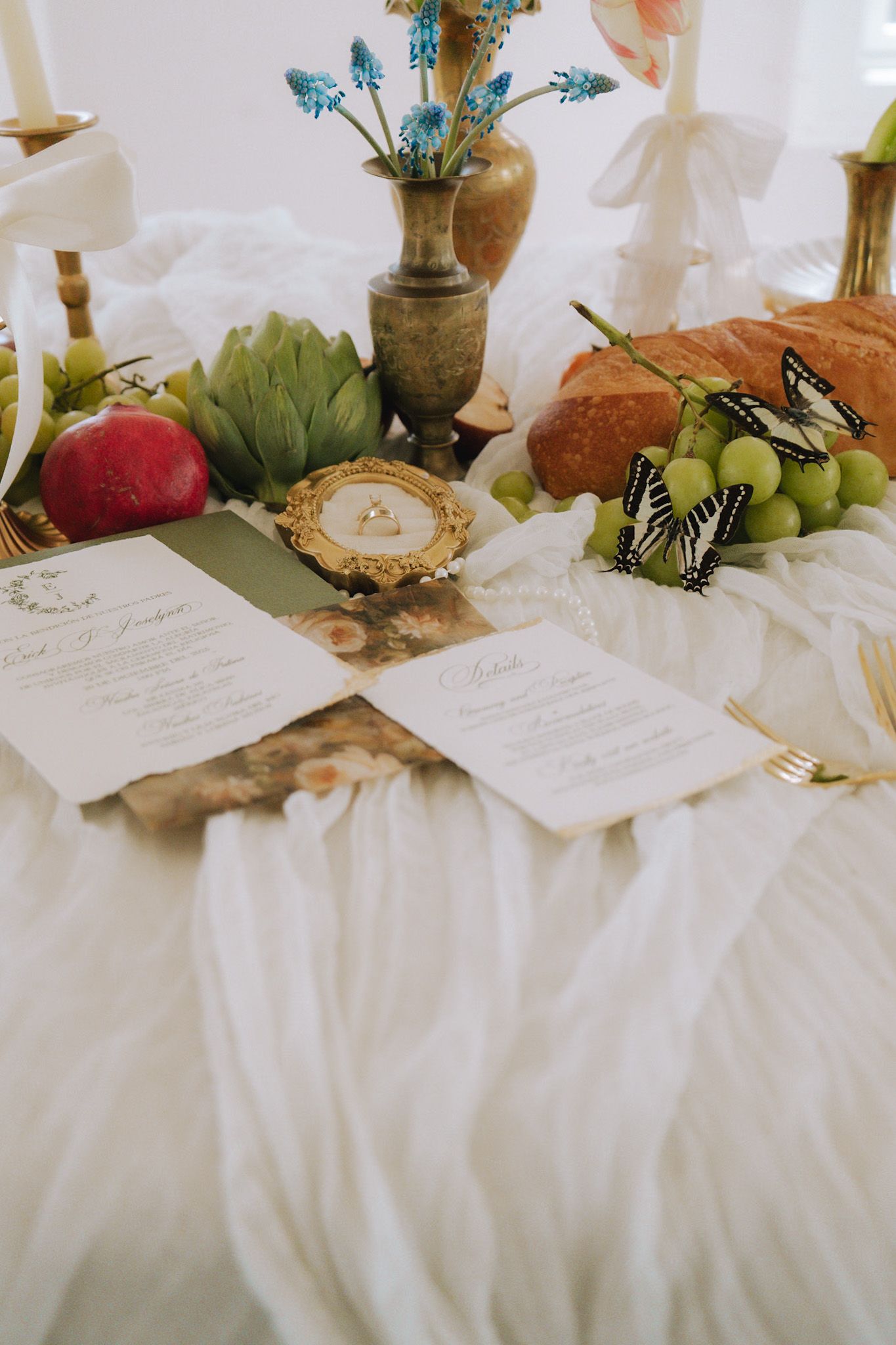 Elegant wedding tablescape with calligraphy menus, butterfly decor, fruit, and golden vases.