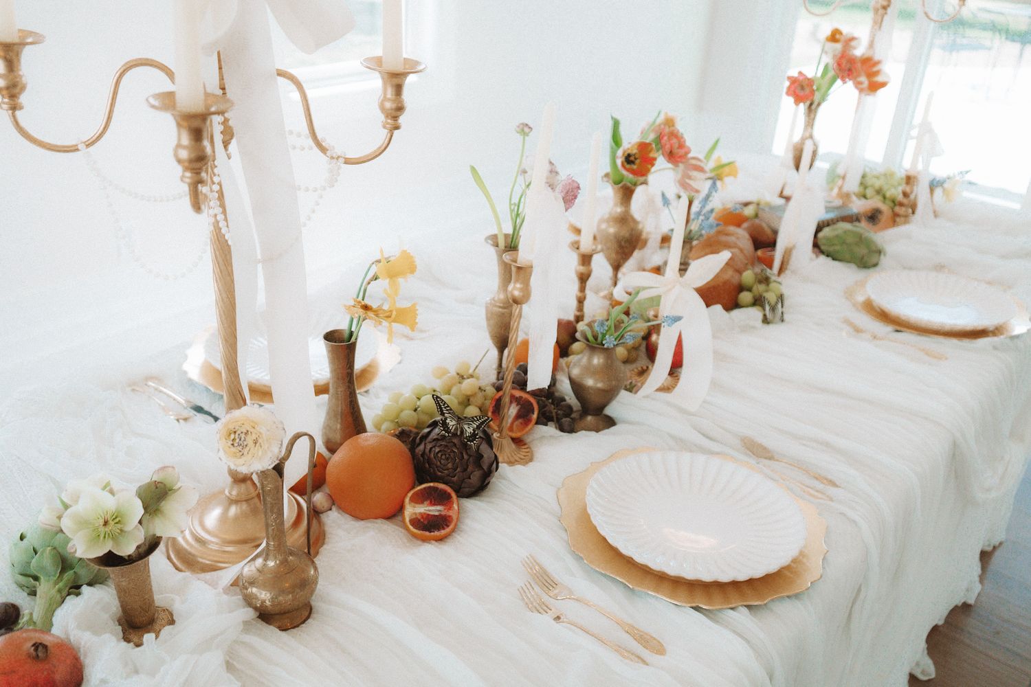 Elegant wedding tablescape with gold candelabra, colorful florals, and white linen runner.