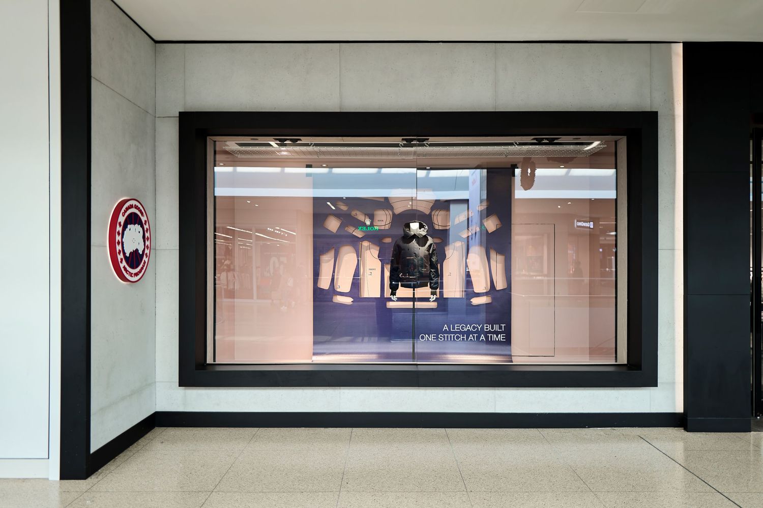 Commercial retail photography by Ayo Erinle — Canada Goose Edmonton storefront window display featuring a mannequin in a black parka.