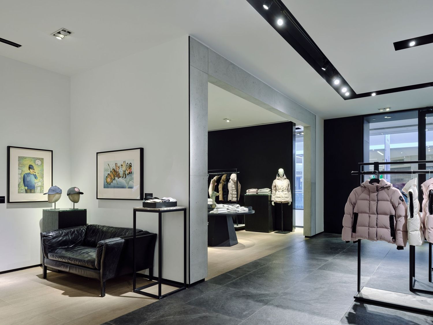 Commercial brand photography by Ayo Erinle — elegant Edmonton retail boutique interior with leather chair, artwork, and outerwear displays.