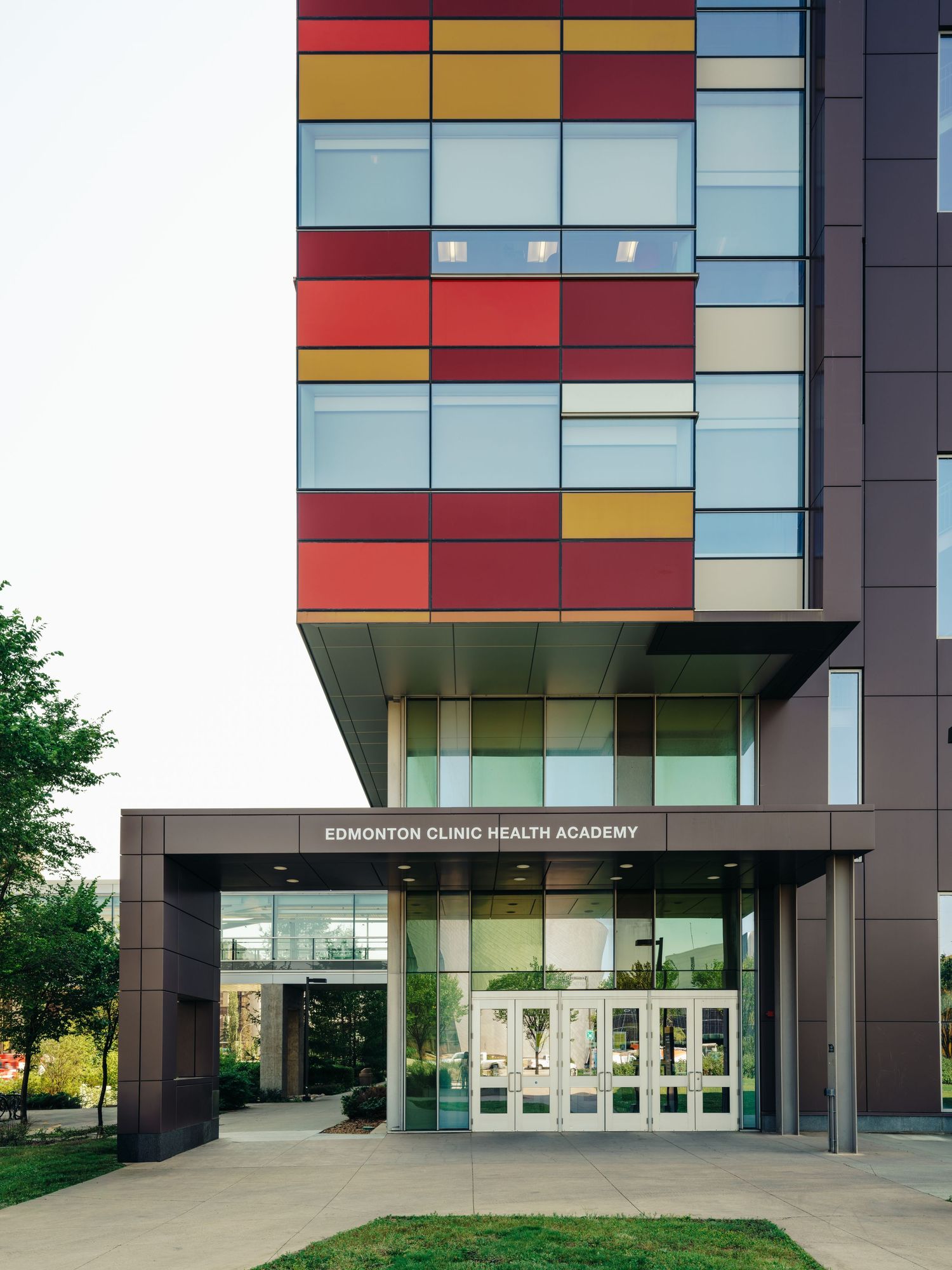 Edmonton Clinic Health Academy entrance featuring colorful red, yellow, and blue facade panels on modern building exterior.
