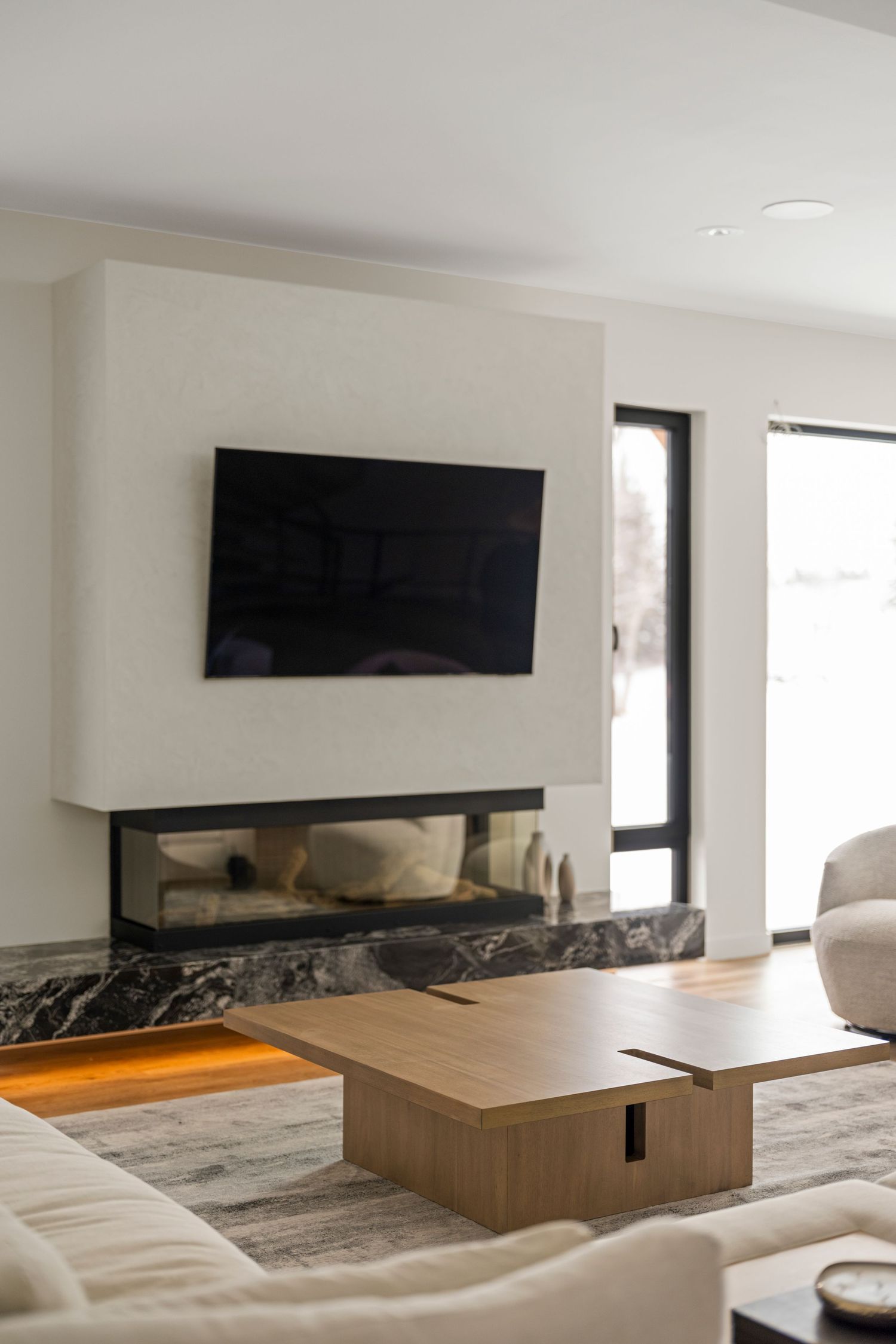 Edmonton interior photography by Ayo Erinle — contemporary living room with white plaster fireplace and marble hearth.
