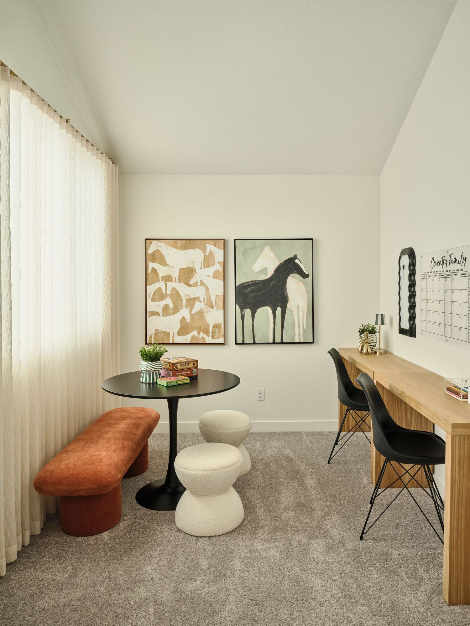 Bright home office and lounge with tulip table, velvet bench, wooden desk, and horse-themed wall art.