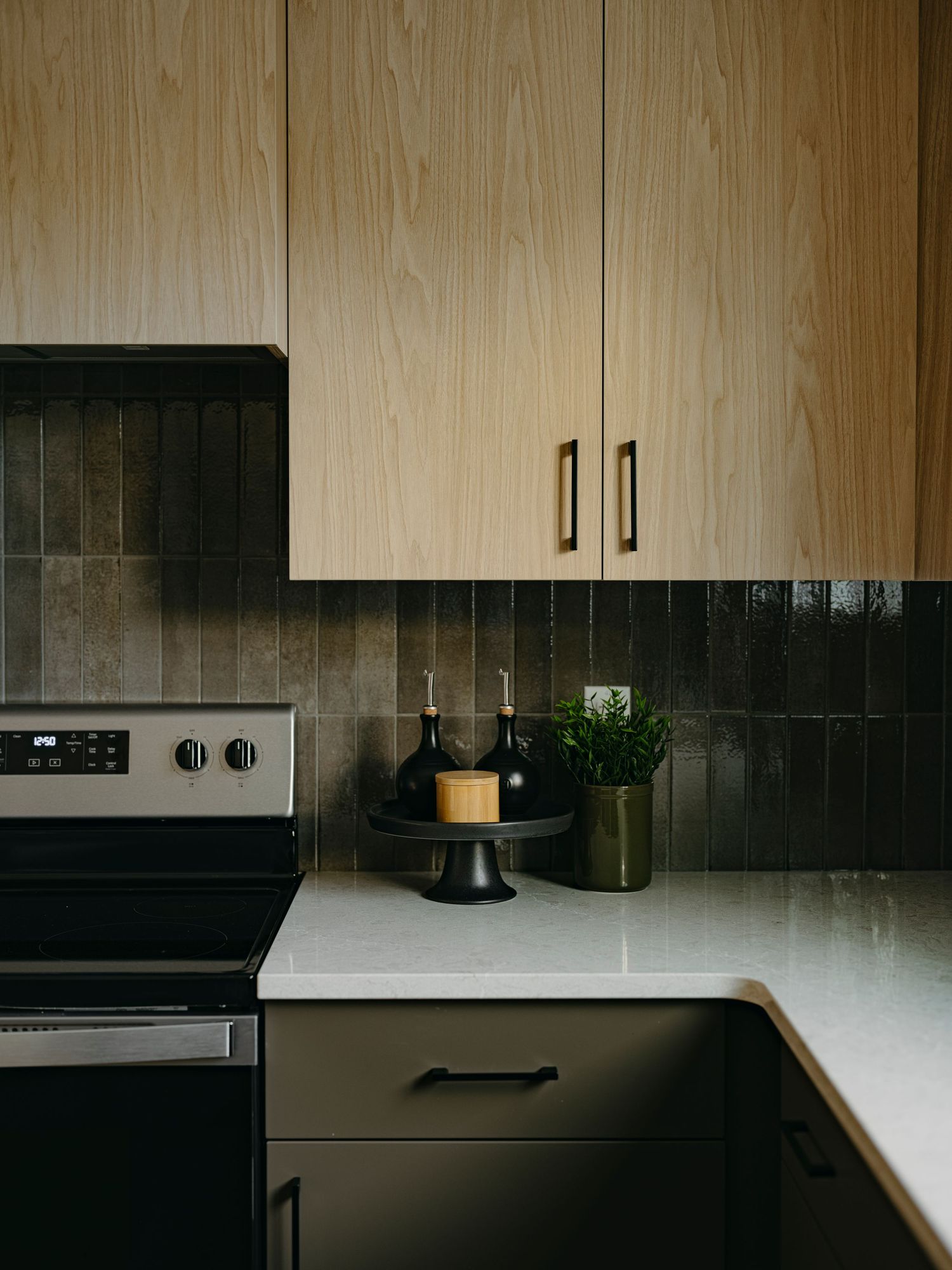 Edmonton interior photography by Ayo Erinle — contemporary kitchen with light wood upper cabinets and tile backsplash.