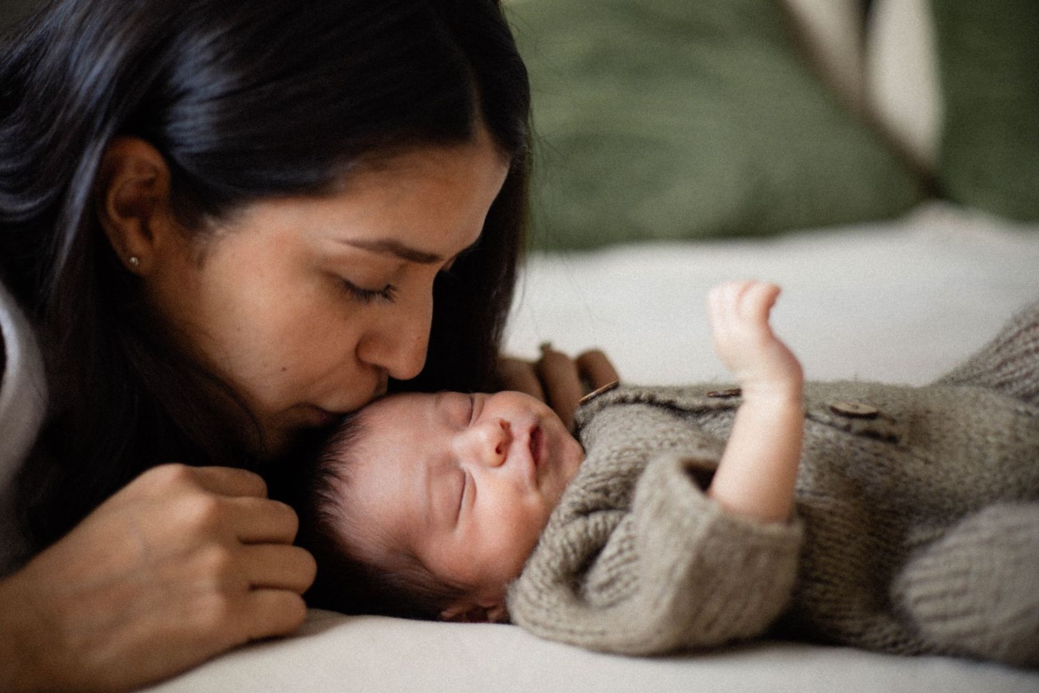 Maman embrassant son nouveau-né — photographe nouveau-né à domicile Rive-Nord Montréal