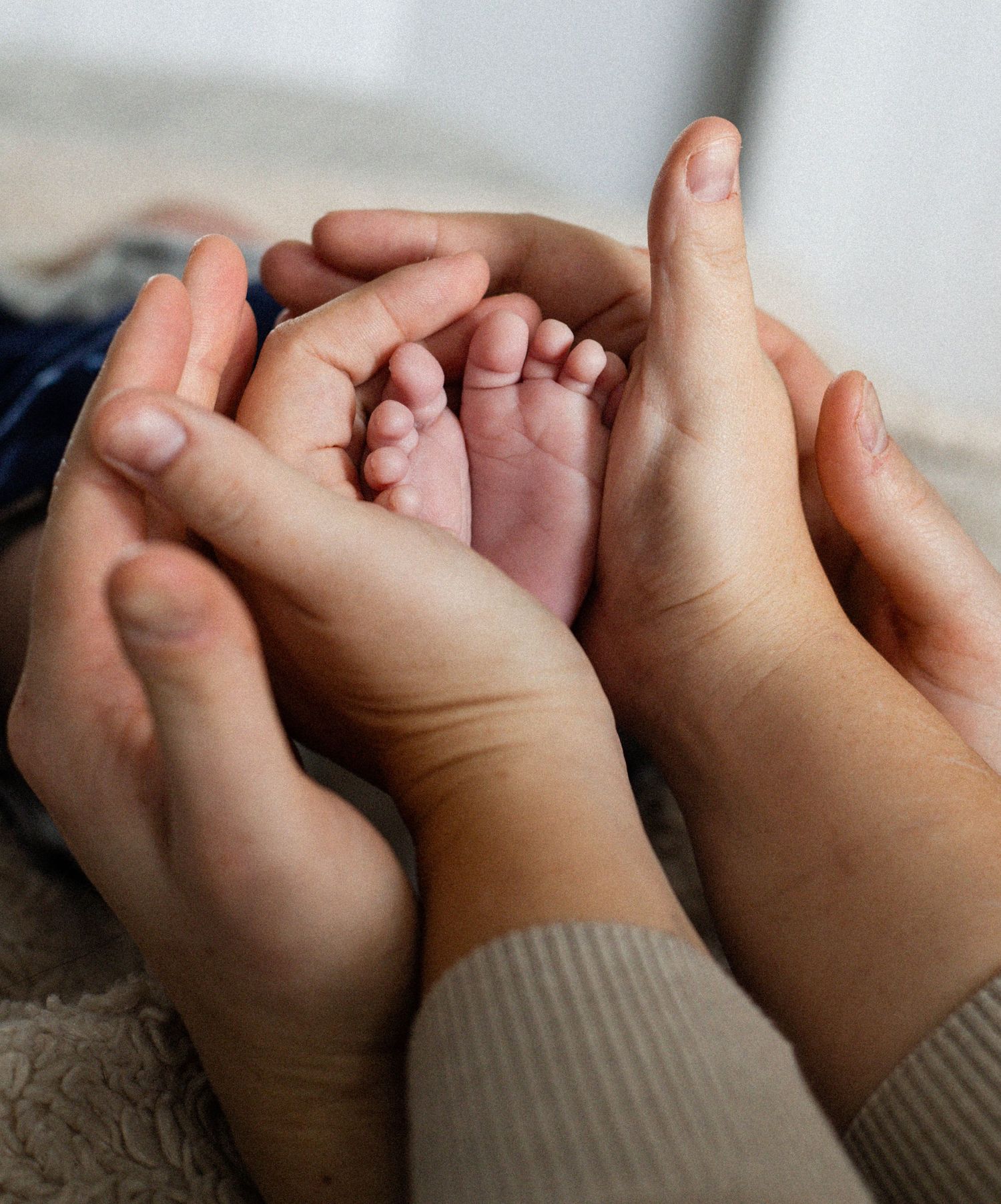 Mains des parents tenant les pieds de bébé — photographe nouveau-né Terrebonne Mascouche