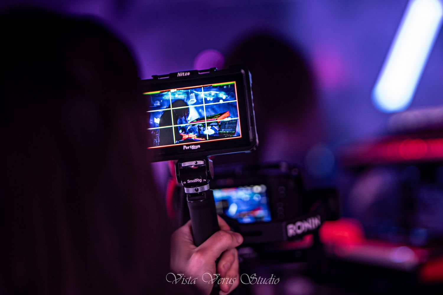 Digital camera screen recording live performance with blue lighting effects.