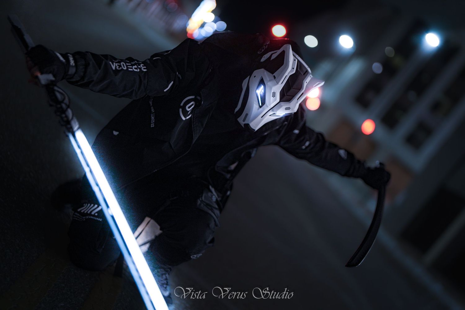 A masked figure in dark clothing with glowing blue LED lights poses with a sword against a nighttime background.