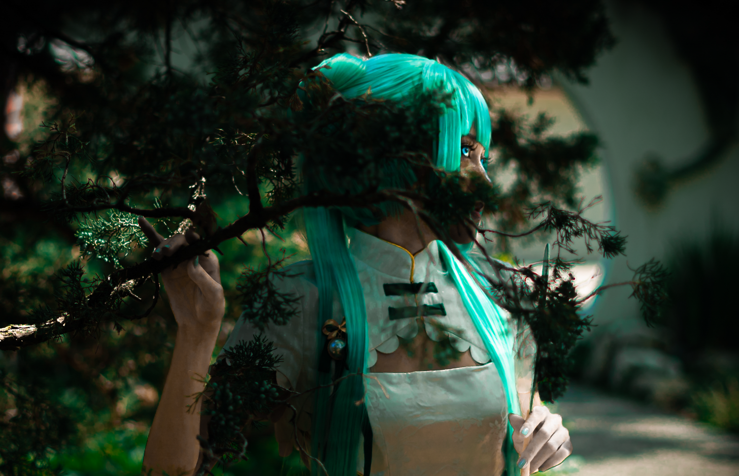 Ethereal turquoise lighting illuminates figure among dark forest branches.