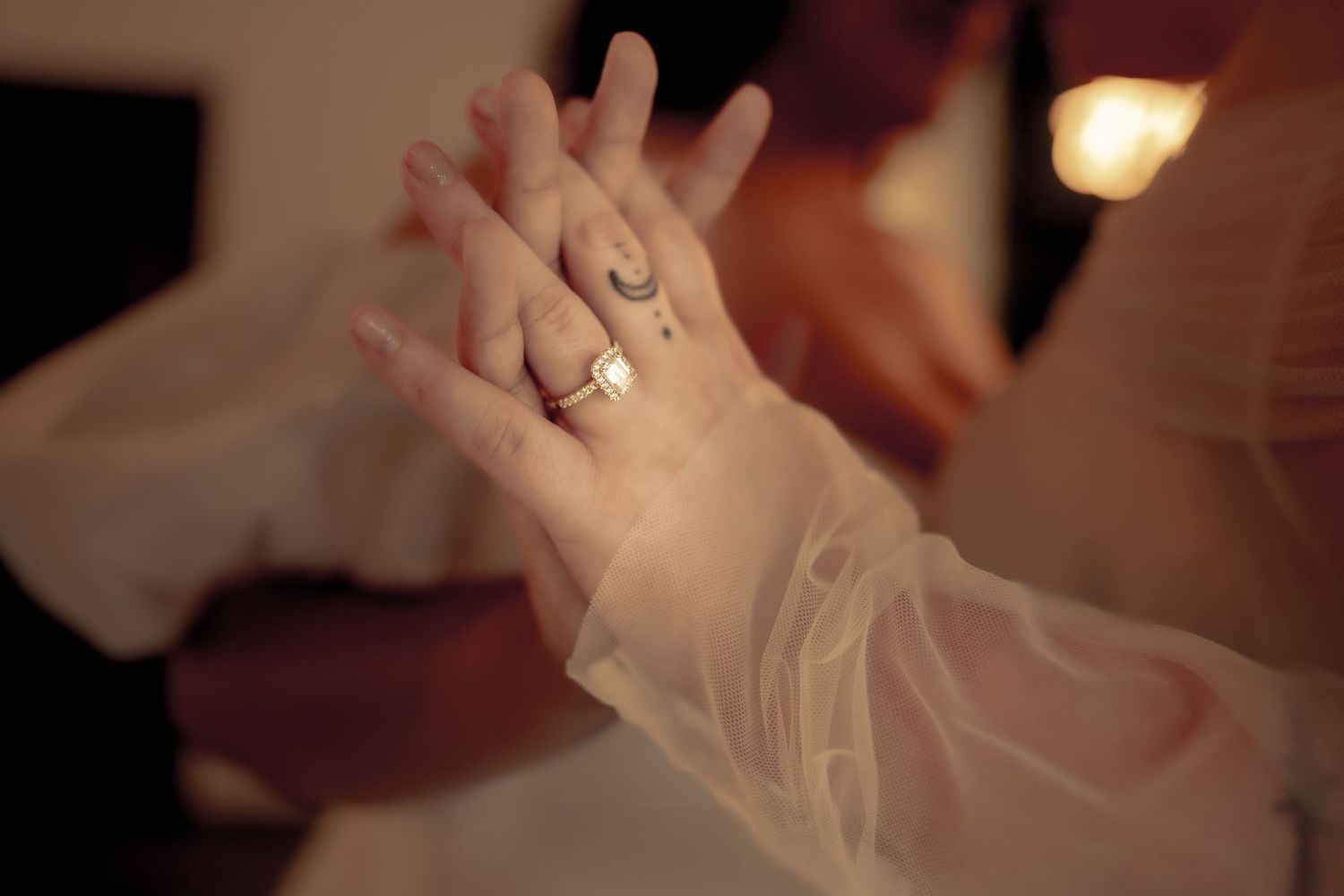 Close-up of wedding rings and hands during ceremony.