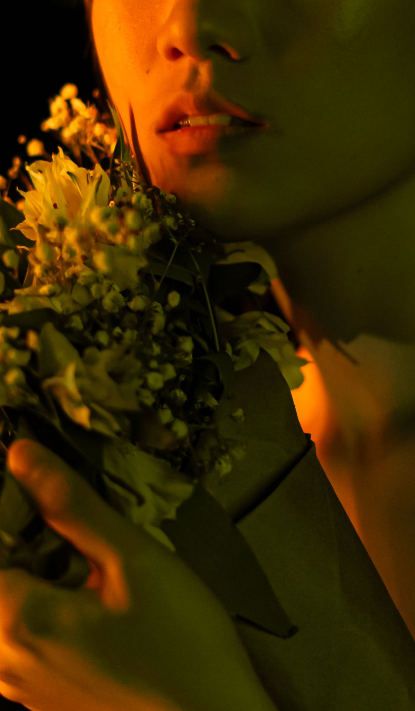Artistic close-up of lips and yellow flowers in warm lighting creating a romantic mood.