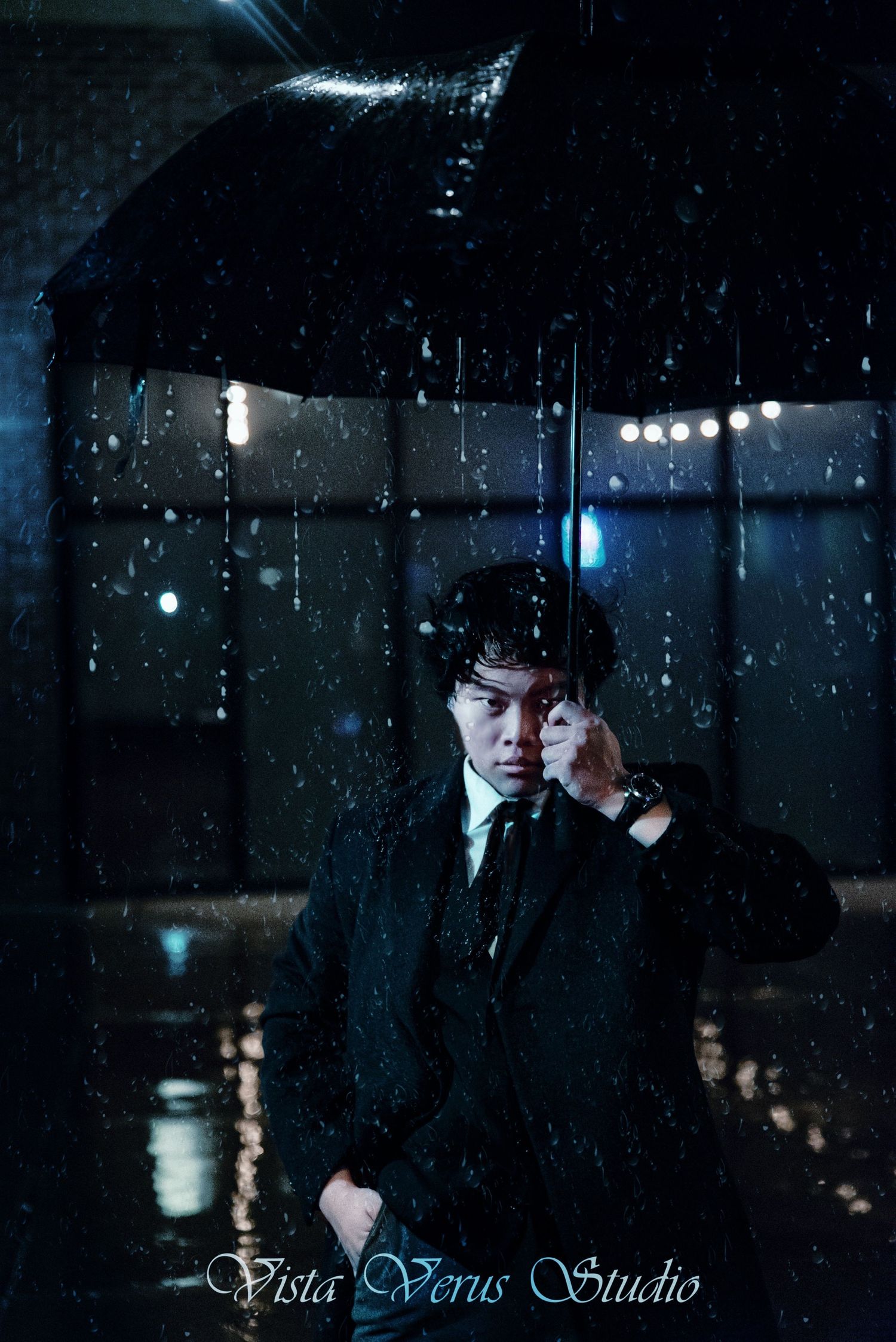 Rainy night portrait with umbrella and suit in dramatic lighting.