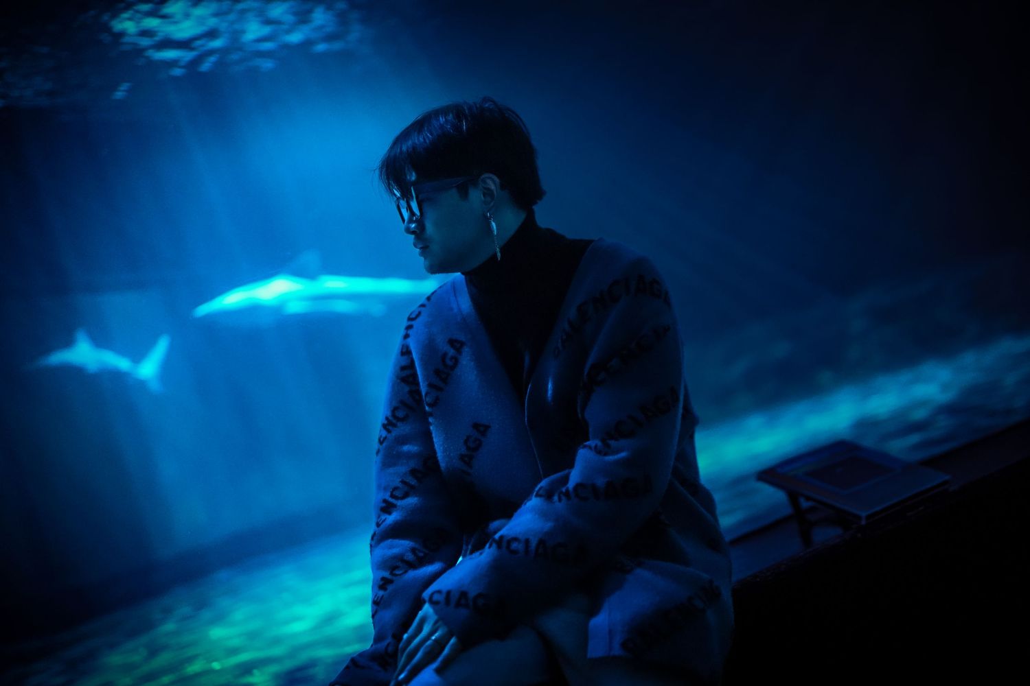 Deep blue underwater lighting creates a moody aquatic atmosphere in series of dark monochromatic shots.