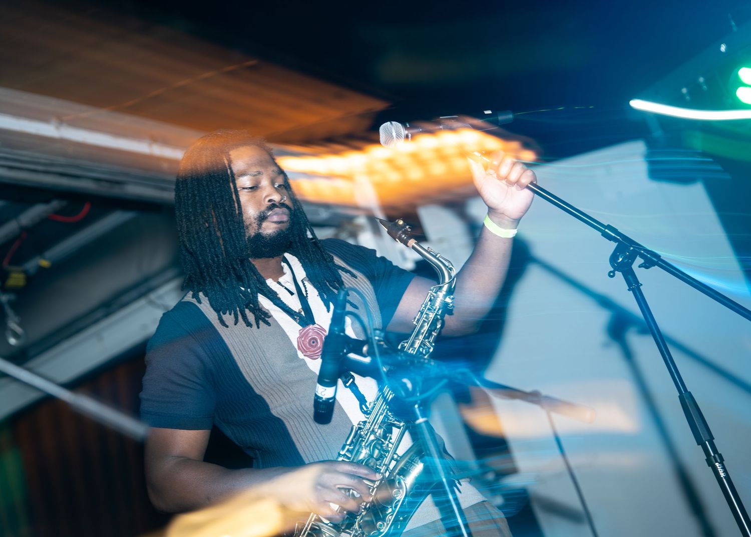 Musician performing on stage with electric guitar in dramatic blue and orange lighting during live concert.