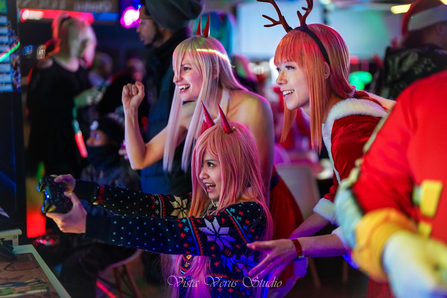 Festive party scene with people dancing and celebrating under colorful lights.