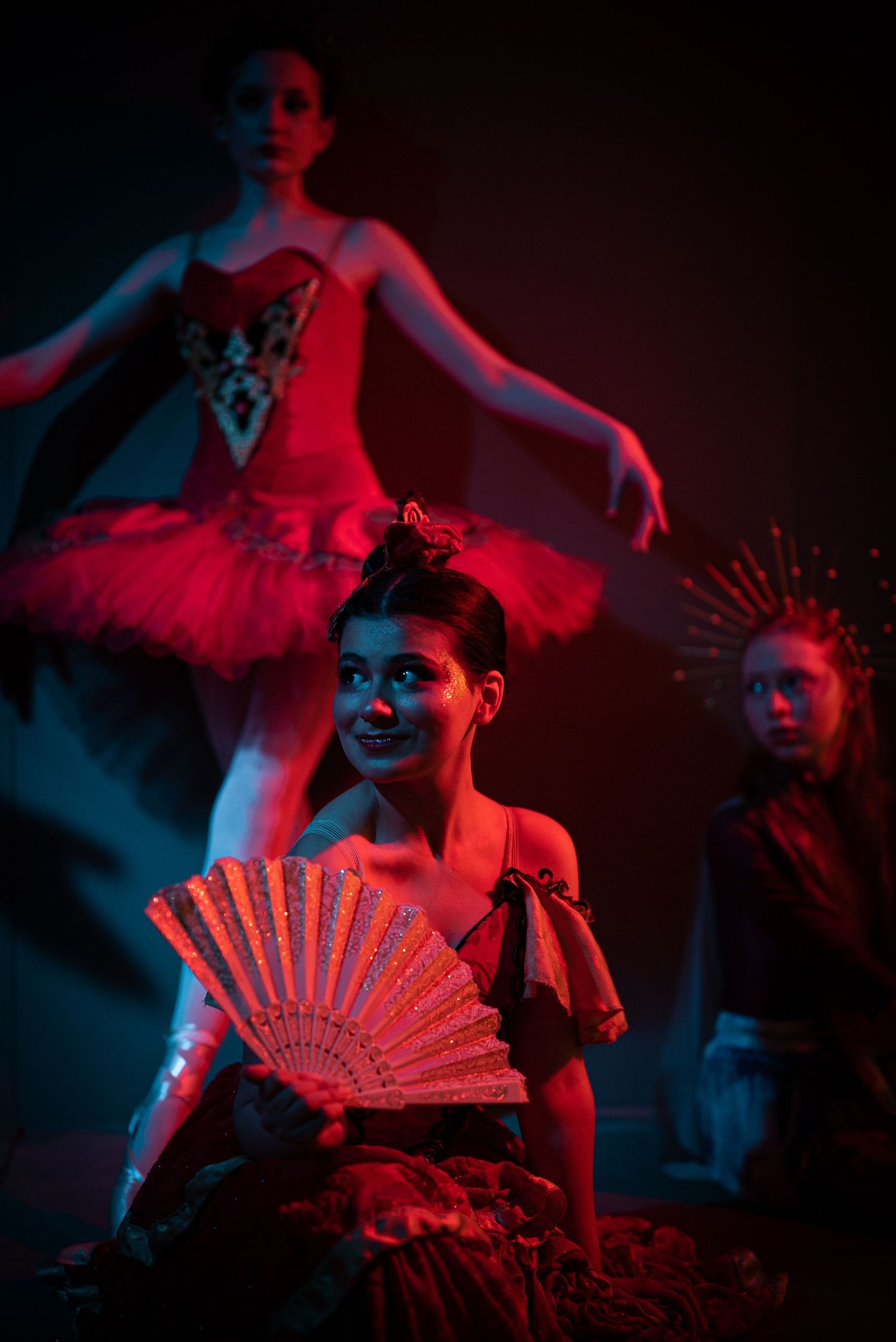 Performance scene with decorative fans and dramatic red and blue lighting effects.