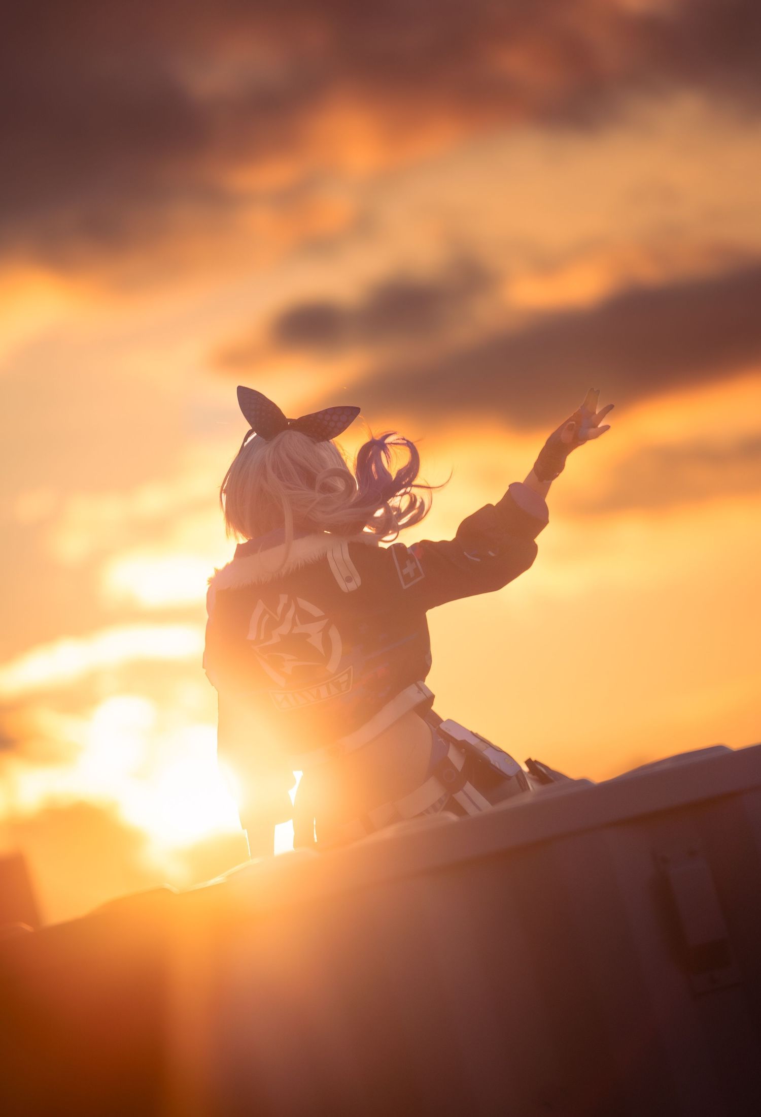 A silhouette of a motorcyclist leaping through the air against a dramatic orange sunset sky.