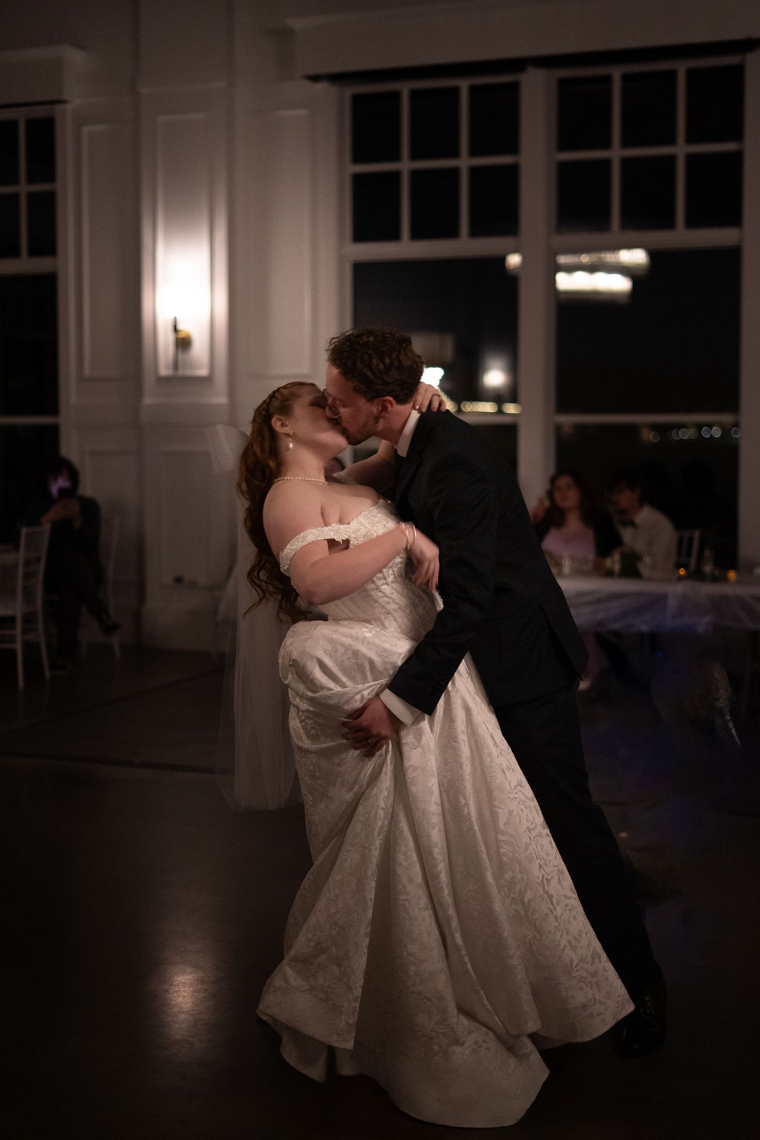 Newlyweds share their first dance in an elegant reception venue.