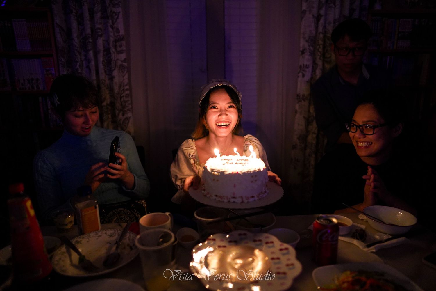 A sequence of dimly lit photos showing a birthday cake with glowing candles creating a warm, celebratory ambiance.