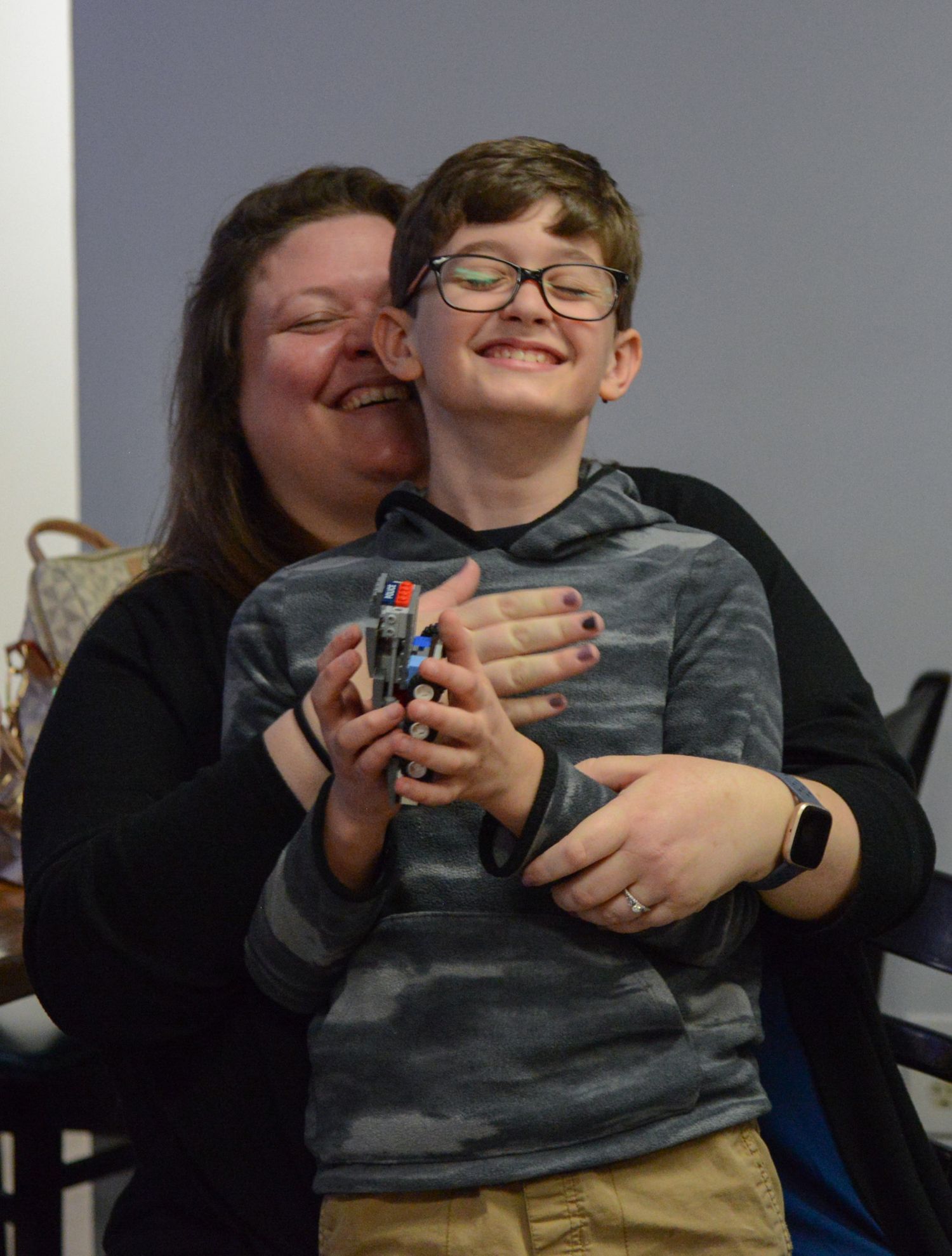 Declan McGuire, 10, smiles as his mom, Erin McGuire, hugs him during the Lego Racer Derby