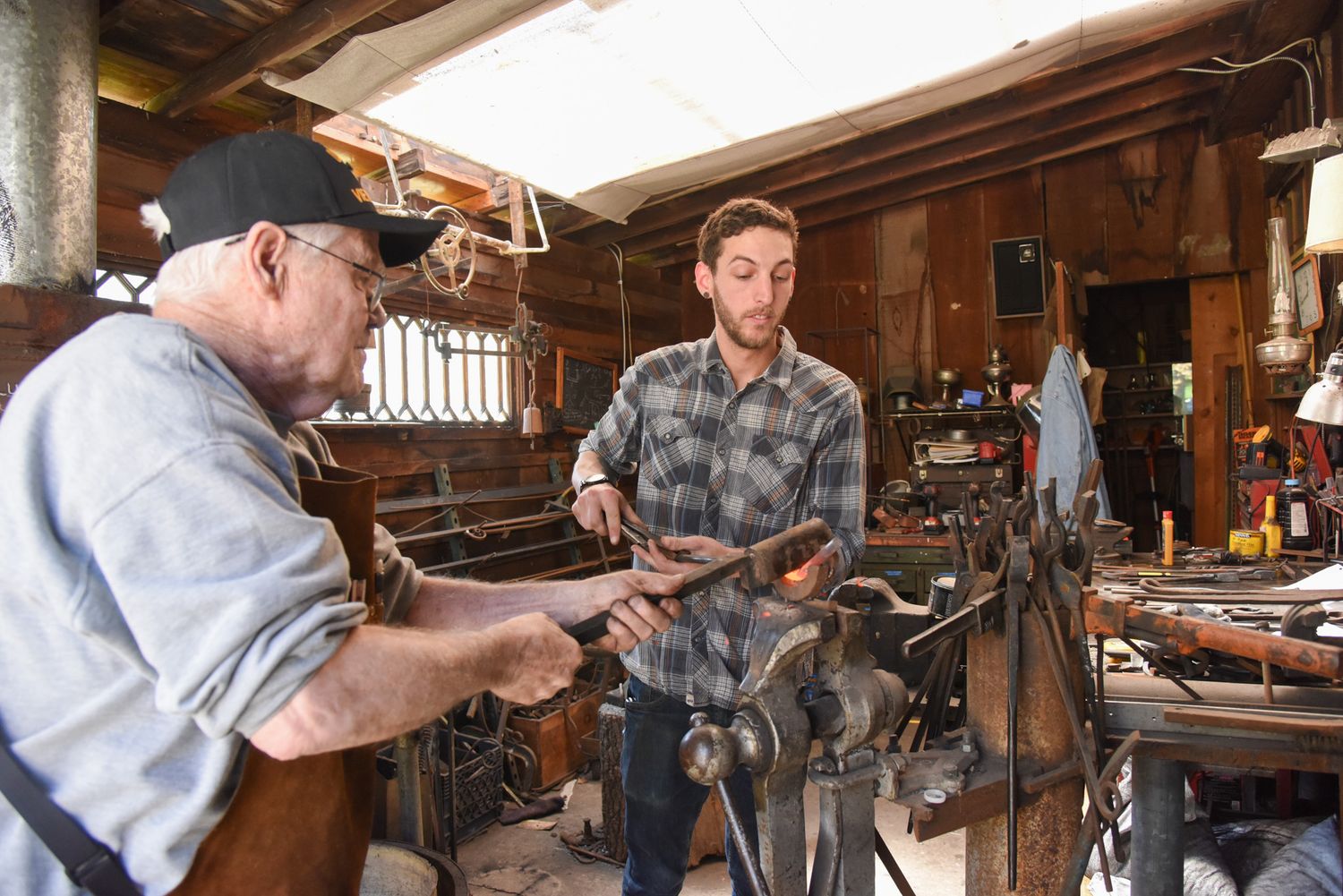 George B. Robb II, left, creates a curve in a piece of metal while Bradley Whittington holds onto it