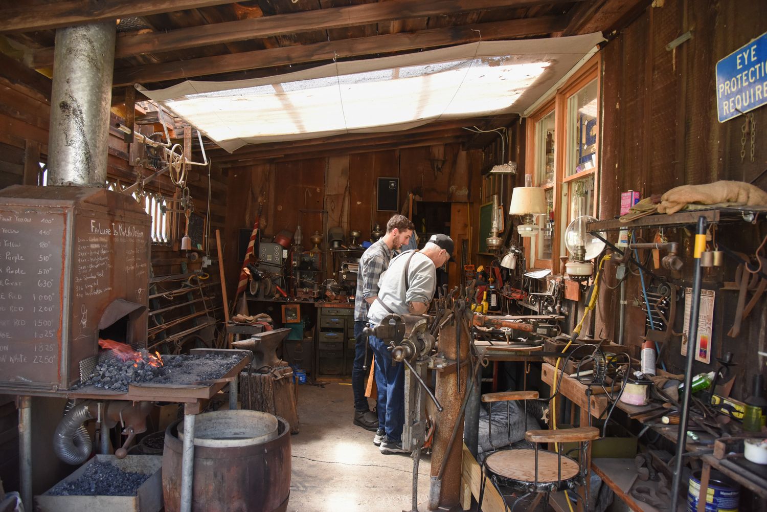 Light filters in through a skylight as Bradley Whittington, left, and George B. Robb II, right, look at a project