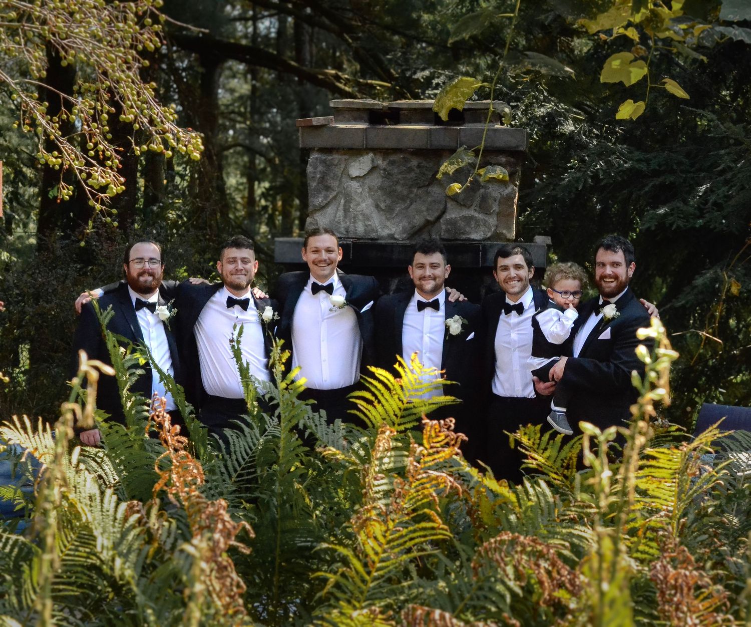 Wedding party in formal attire standing among autumn foliage. Wedding photos by KM Conceptions Photography in Danville, OH.