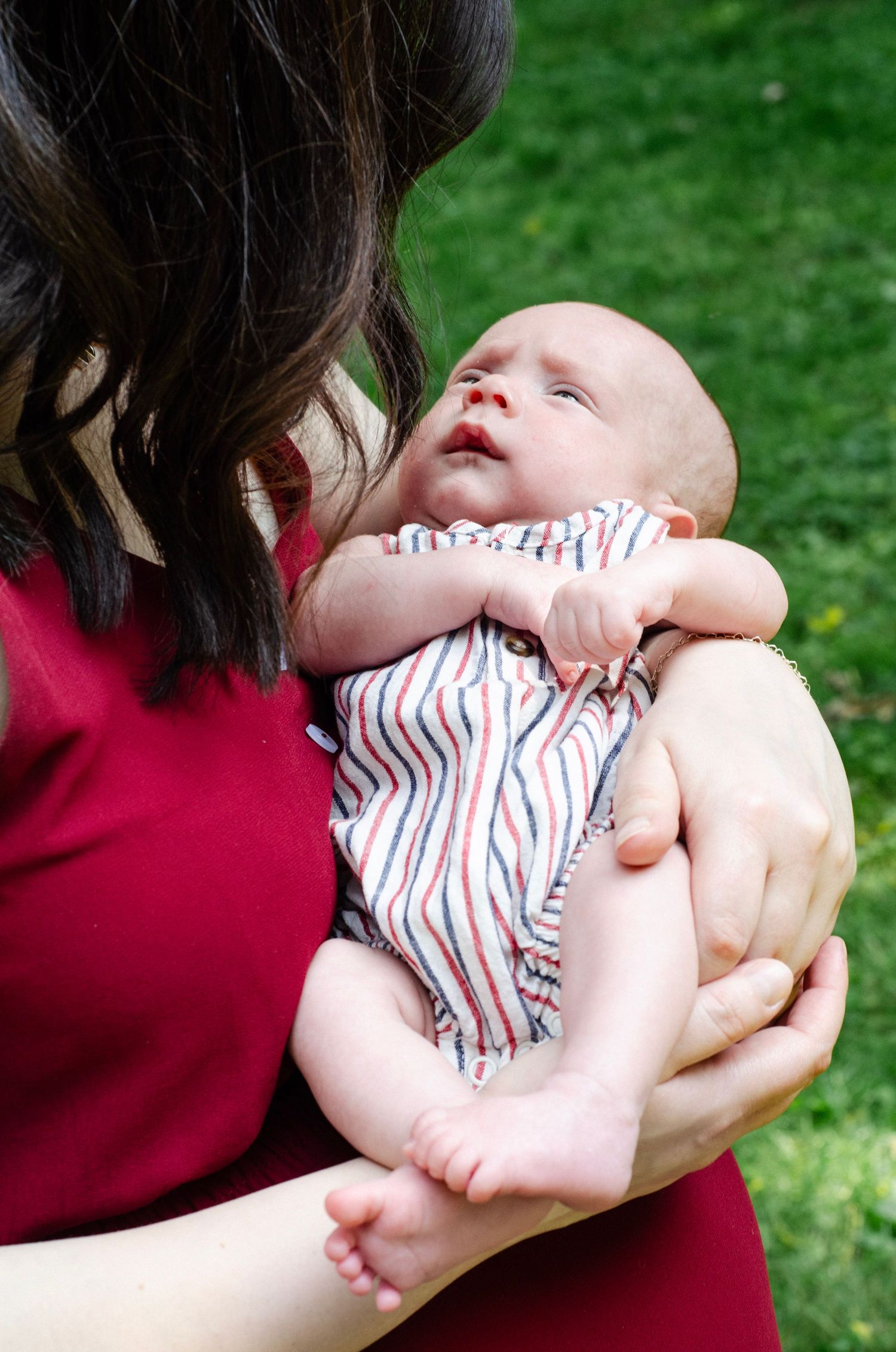 A tender moment between parent and infant on a sunny day outdoors. Newborn photos by KM Conceptions Photography in Columbus, OH.